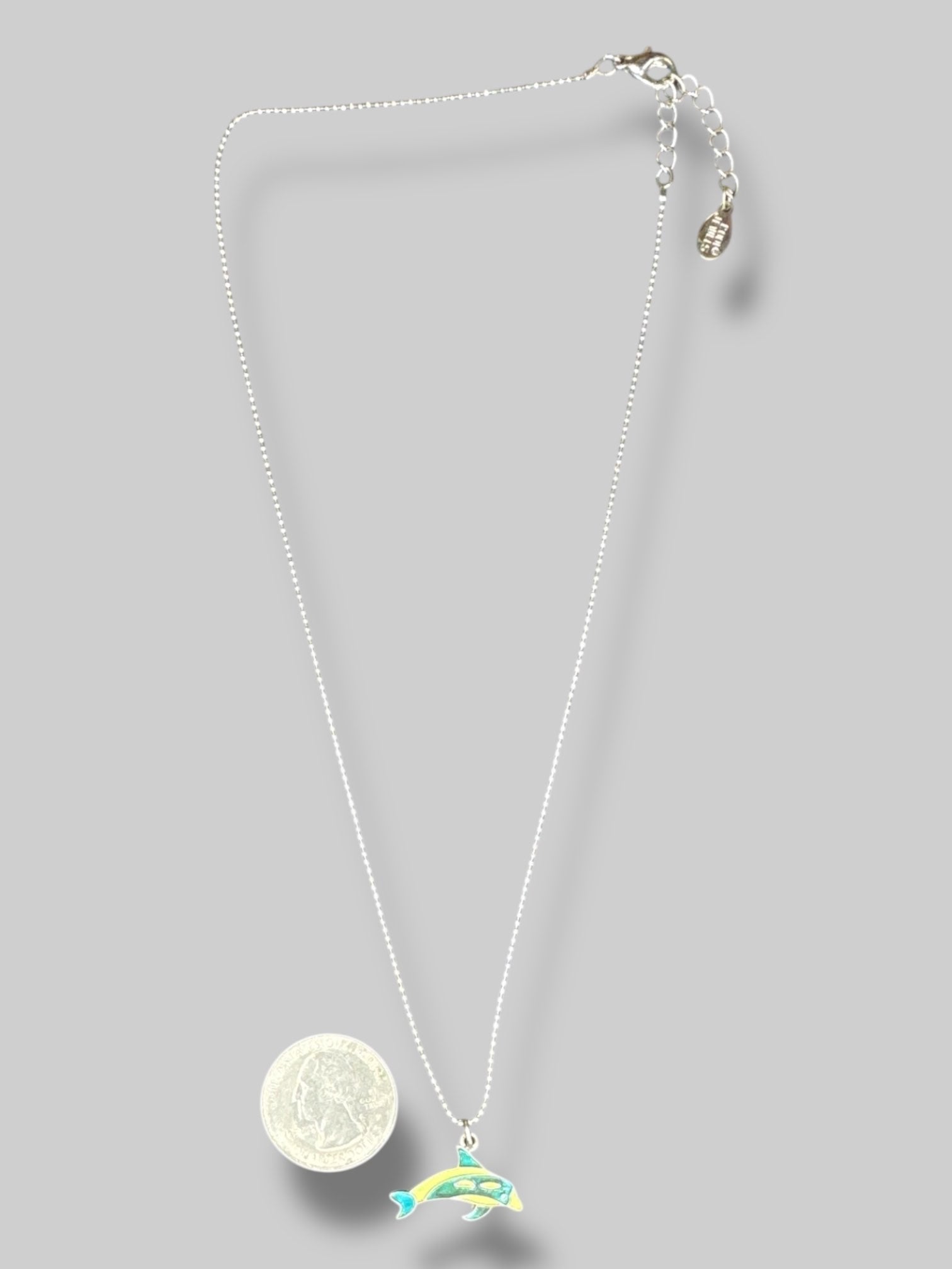 Silver colored necklace with green and blue dolphin pendant