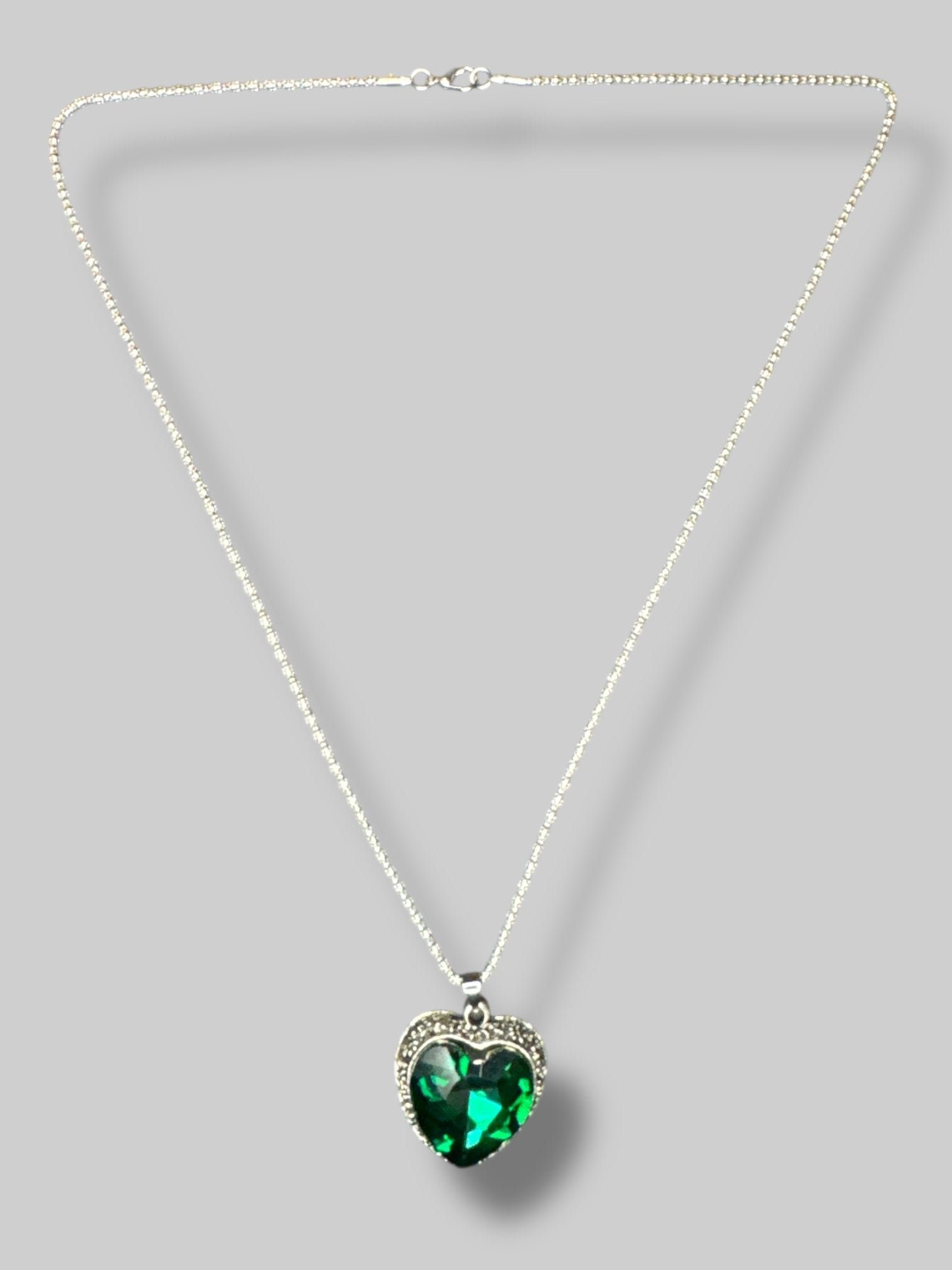 Silver color chain with emerald colored heart shape stone necklace