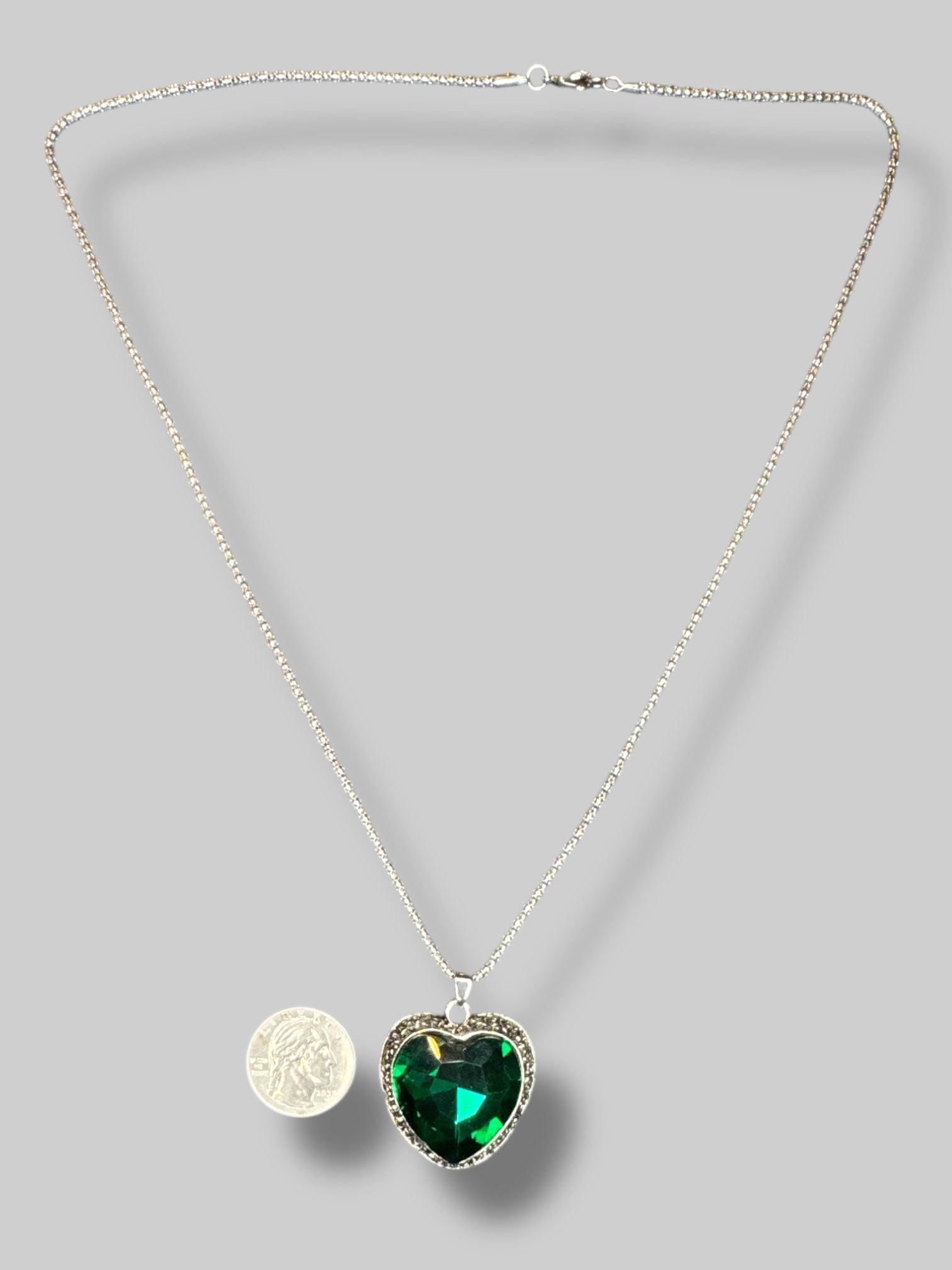 Silver color chain with emerald colored heart shape stone necklace