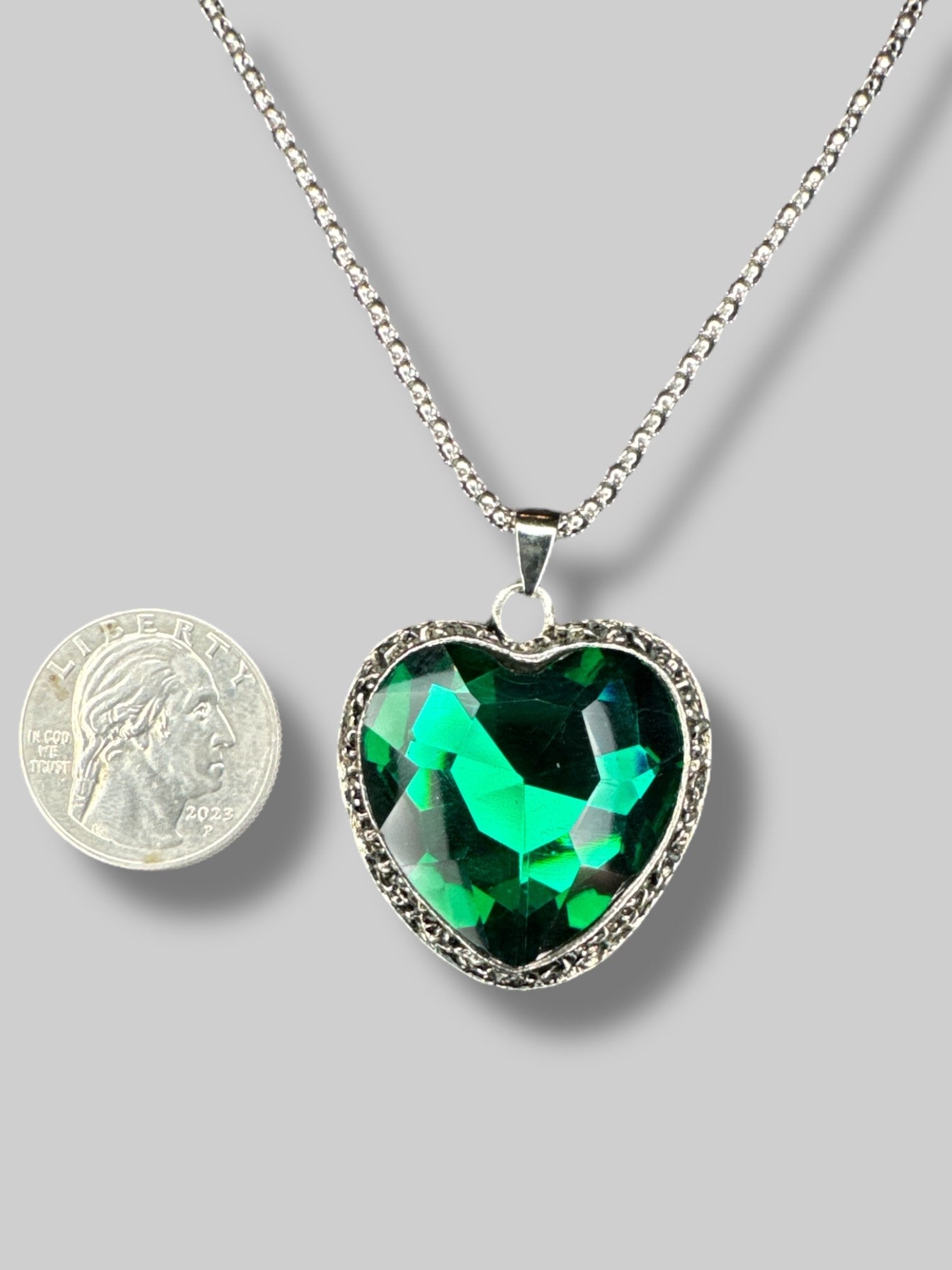 Silver color chain with emerald colored heart shape stone necklace