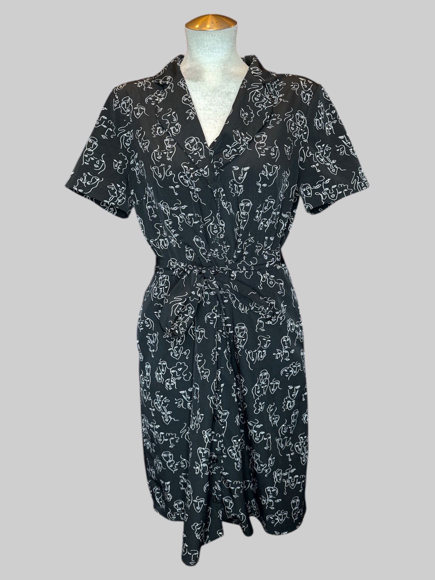 L Black button up dress with white squiggly faces pattern and tie belt