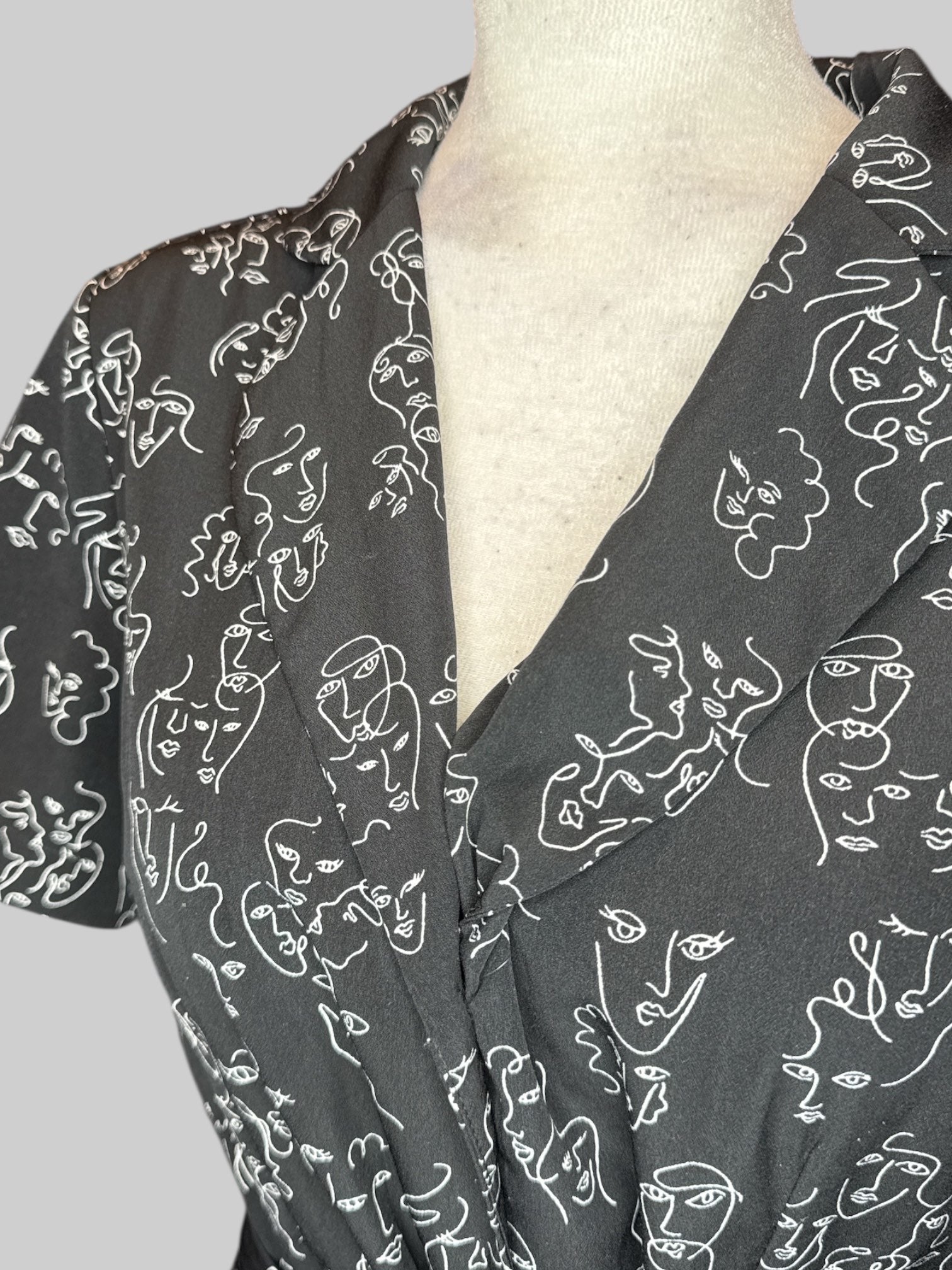 L Black button up dress with white squiggly faces pattern and tie belt