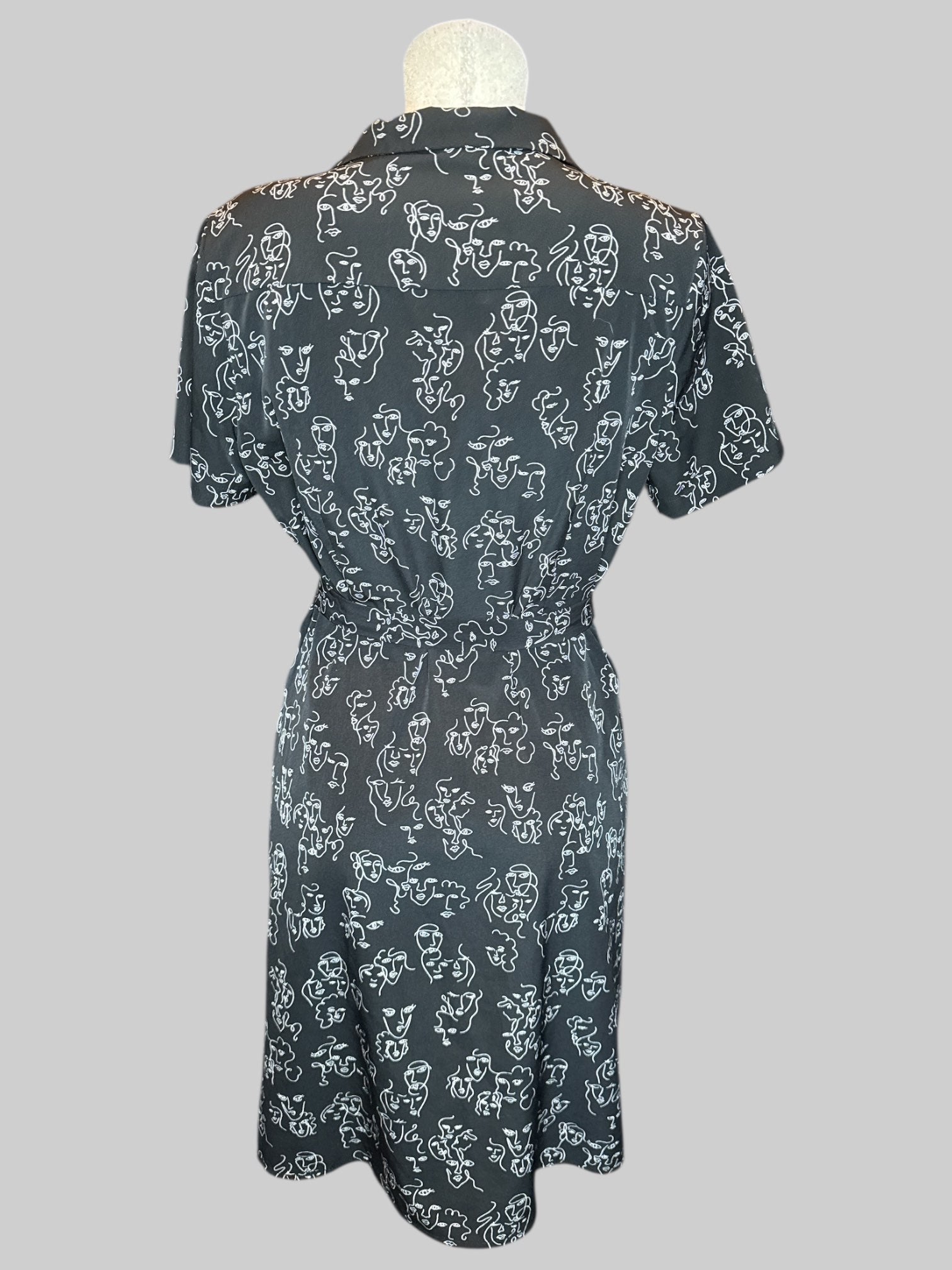 L Black button up dress with white squiggly faces pattern and tie belt