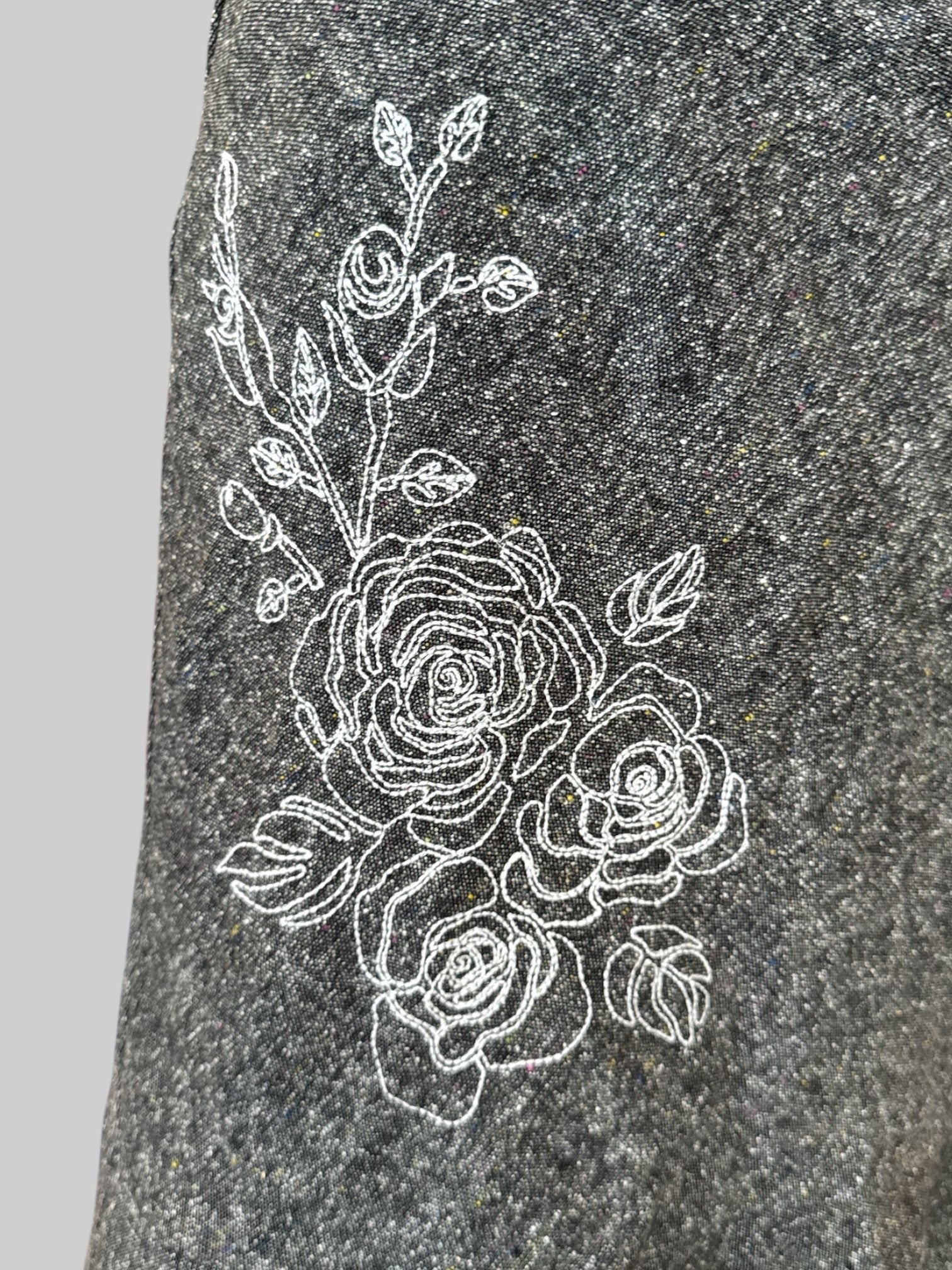 L Vintage grey skirt with speckles of yellow and red, white floral embroidery, and black trim