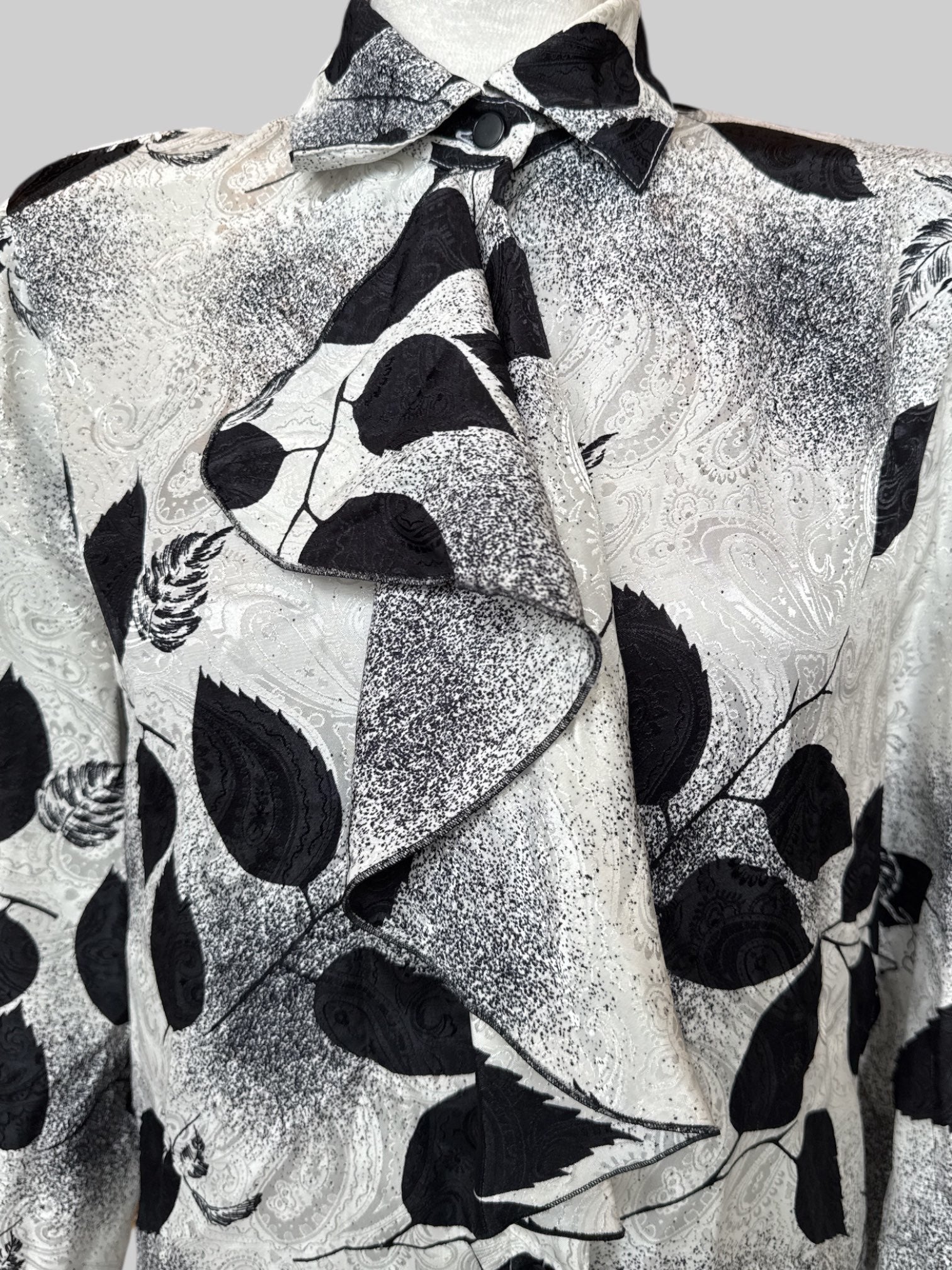 M Vintage white button up with black botanicals and speckles, textured paisley pattern, and front ruffle