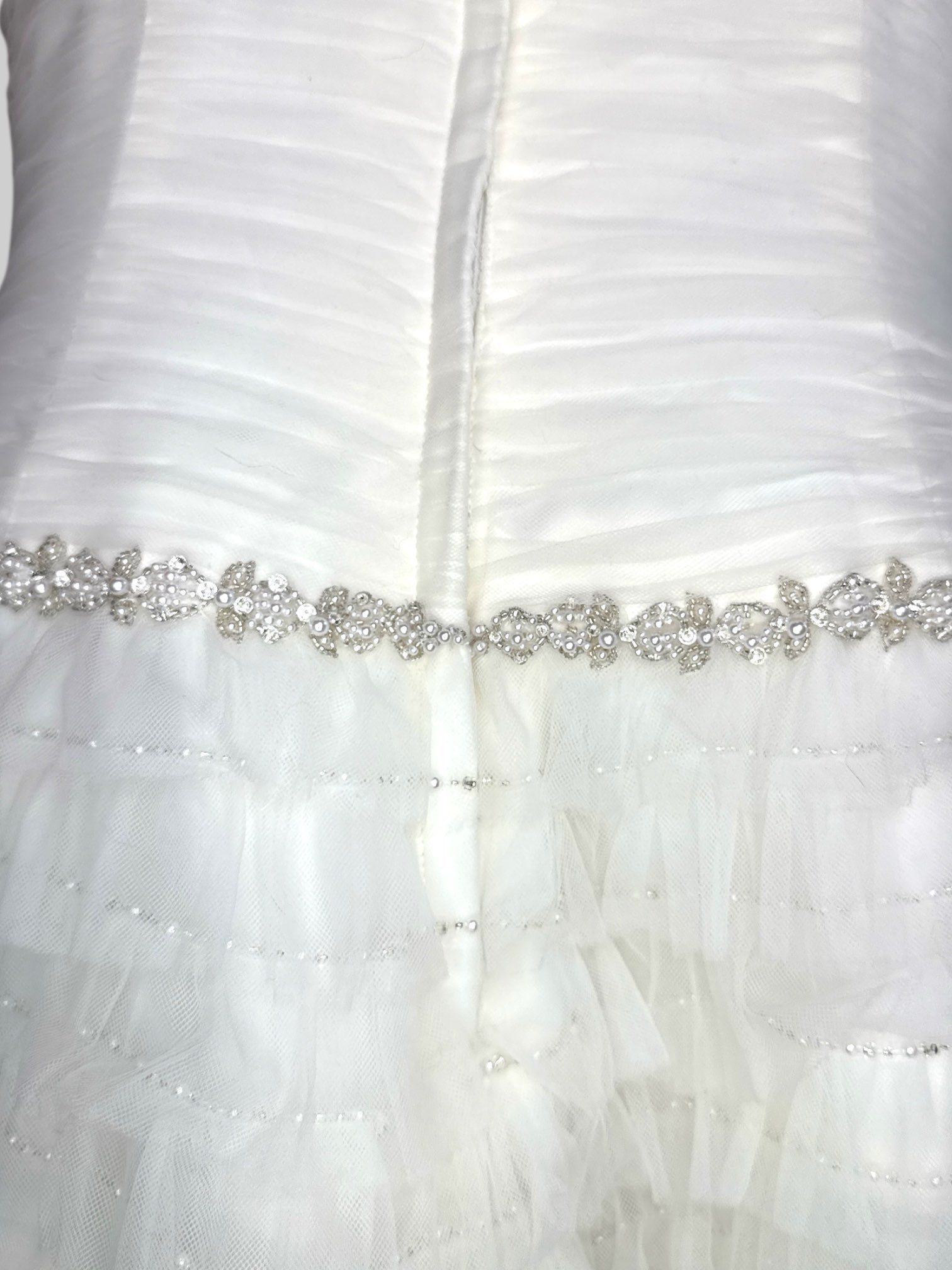 L David’s Bridal white wedding reception type dress with tule ruffles that become sheer at the bottom, pearl and stone belt, boning, and ruched bodice