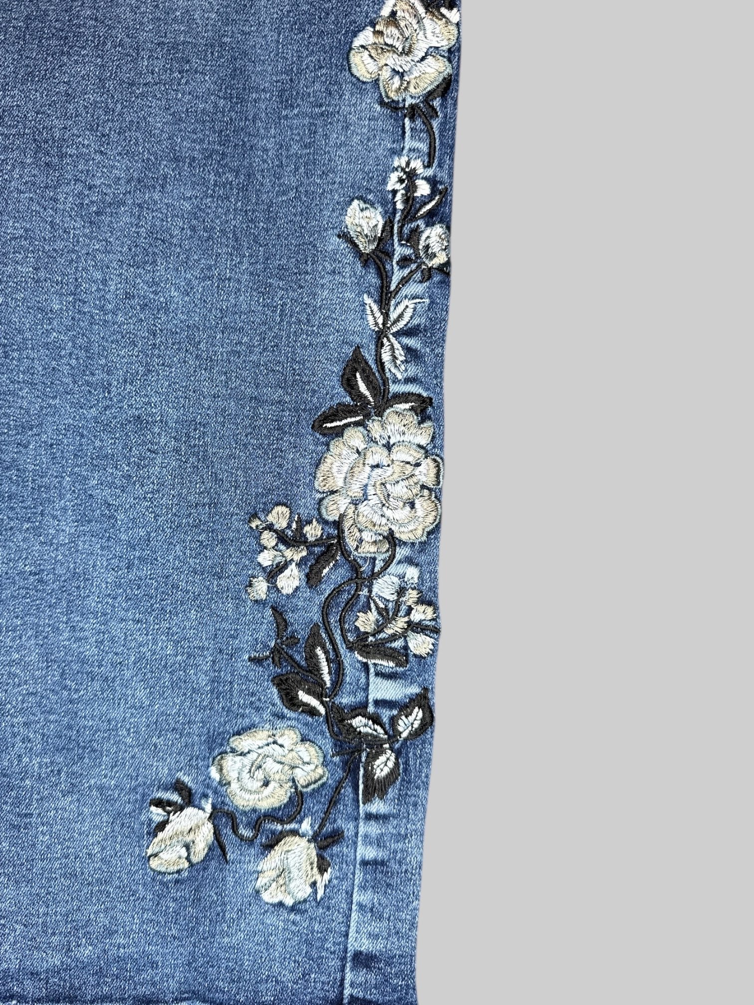 L Blue jeans with floral embroidery on bottoms