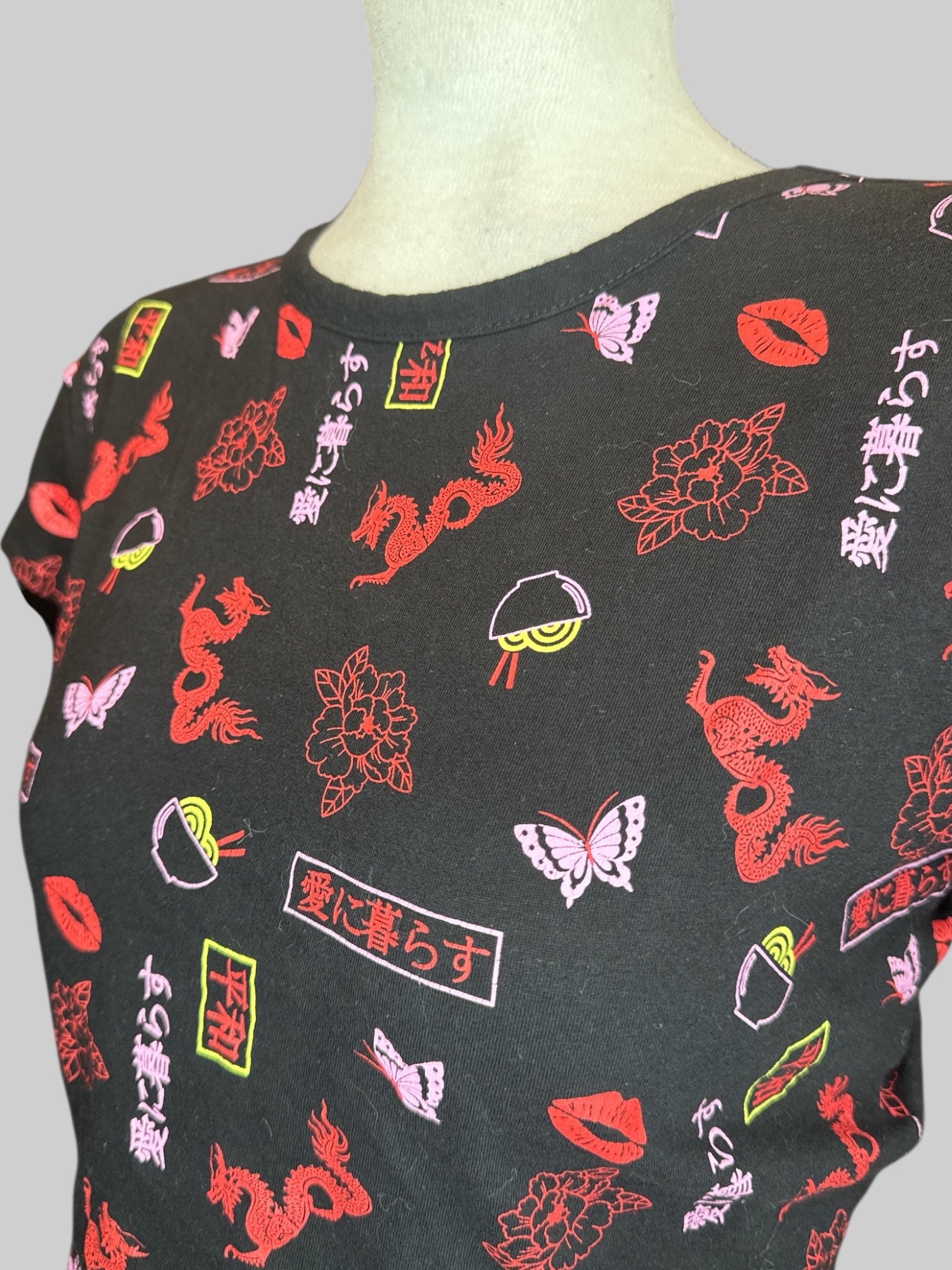 XL black crop top with red, pink, and yellow graphics, open back, and tie