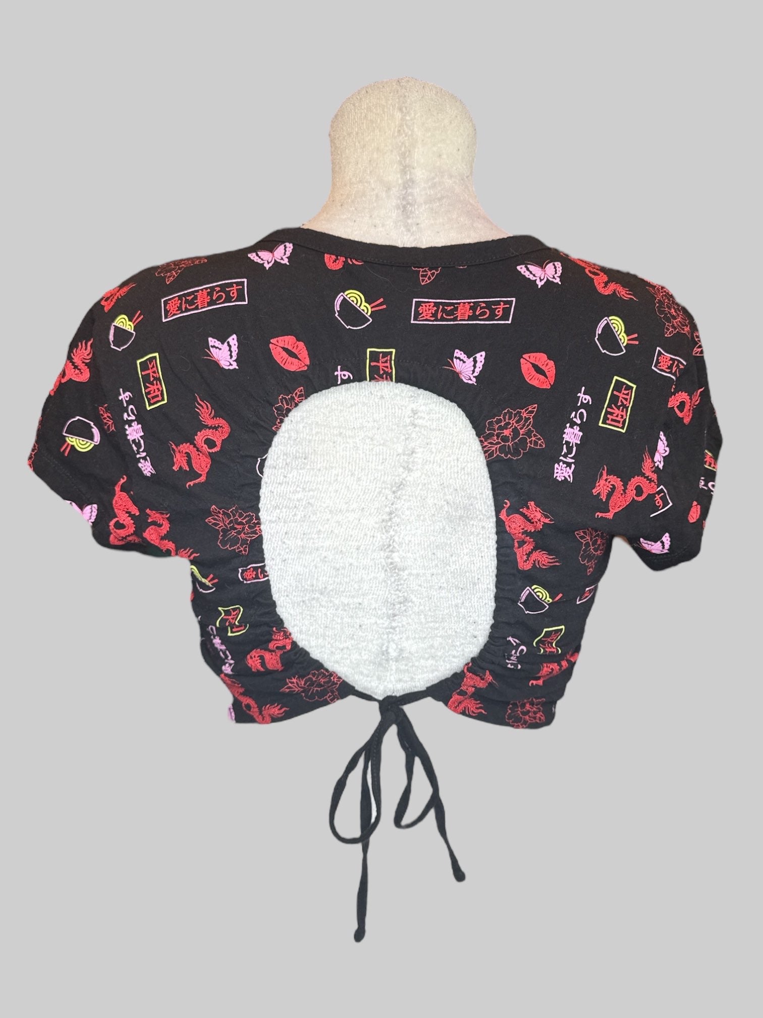 XL black crop top with red, pink, and yellow graphics, open back, and tie