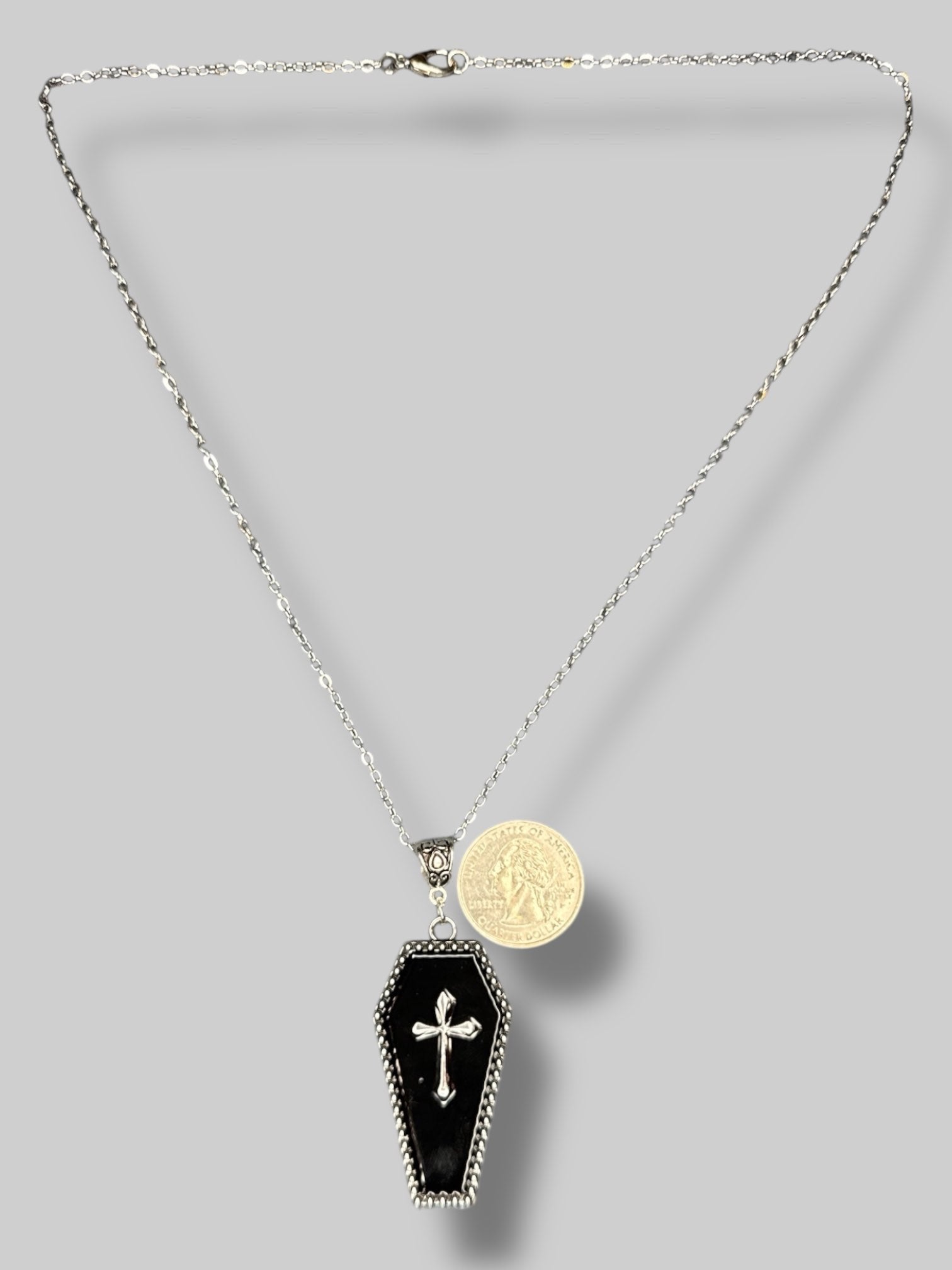 Silver tone necklace with black coffin pendant