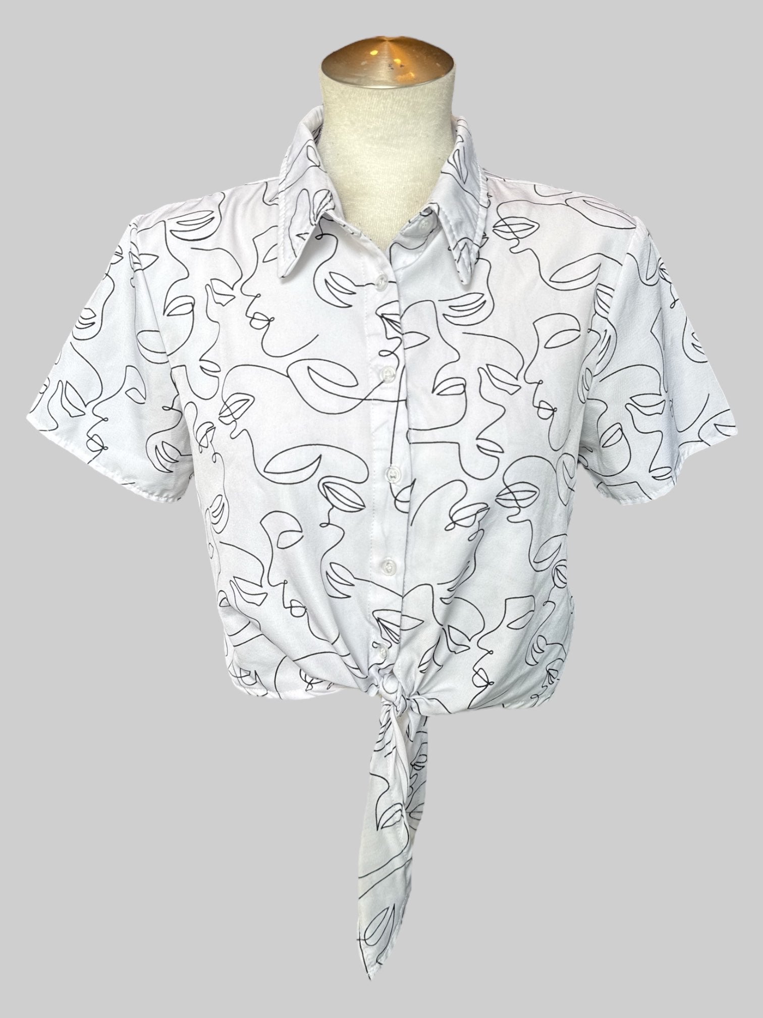 M White button up crop top with black abstract line faces and tie