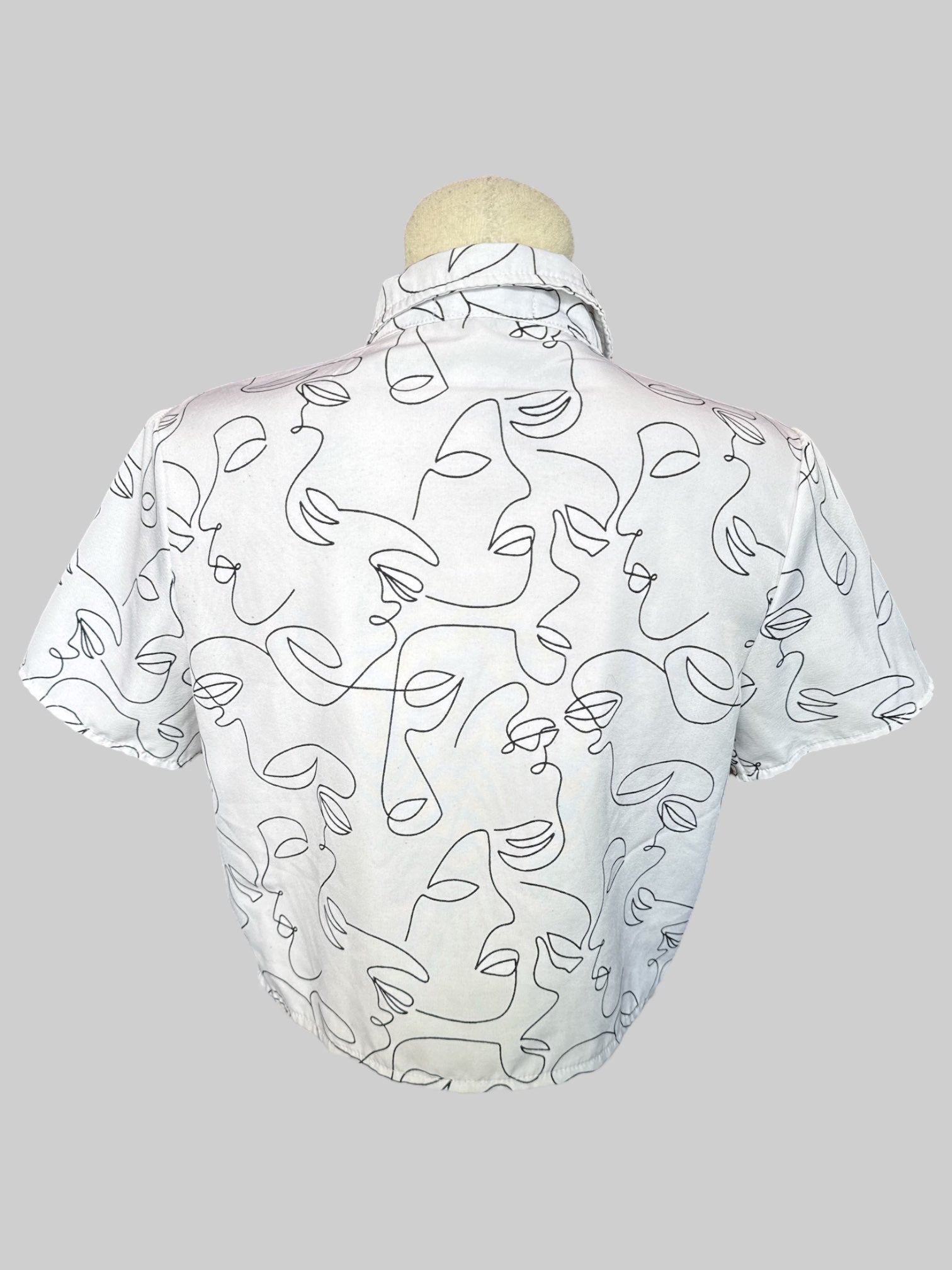M White button up crop top with black abstract line faces and tie