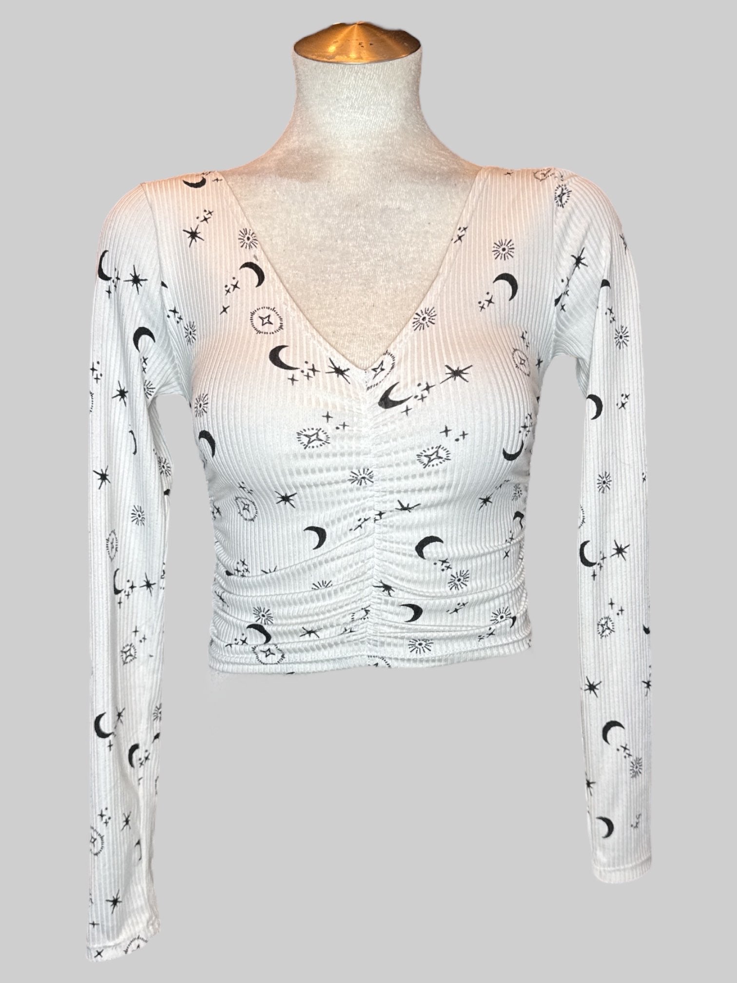 S White long sleeve top with black celestial pattern and ruching in the middle