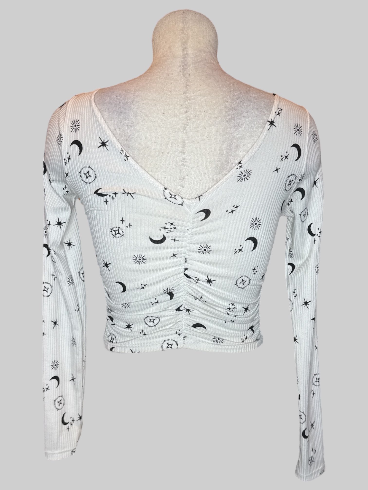 S White long sleeve top with black celestial pattern and ruching in the middle