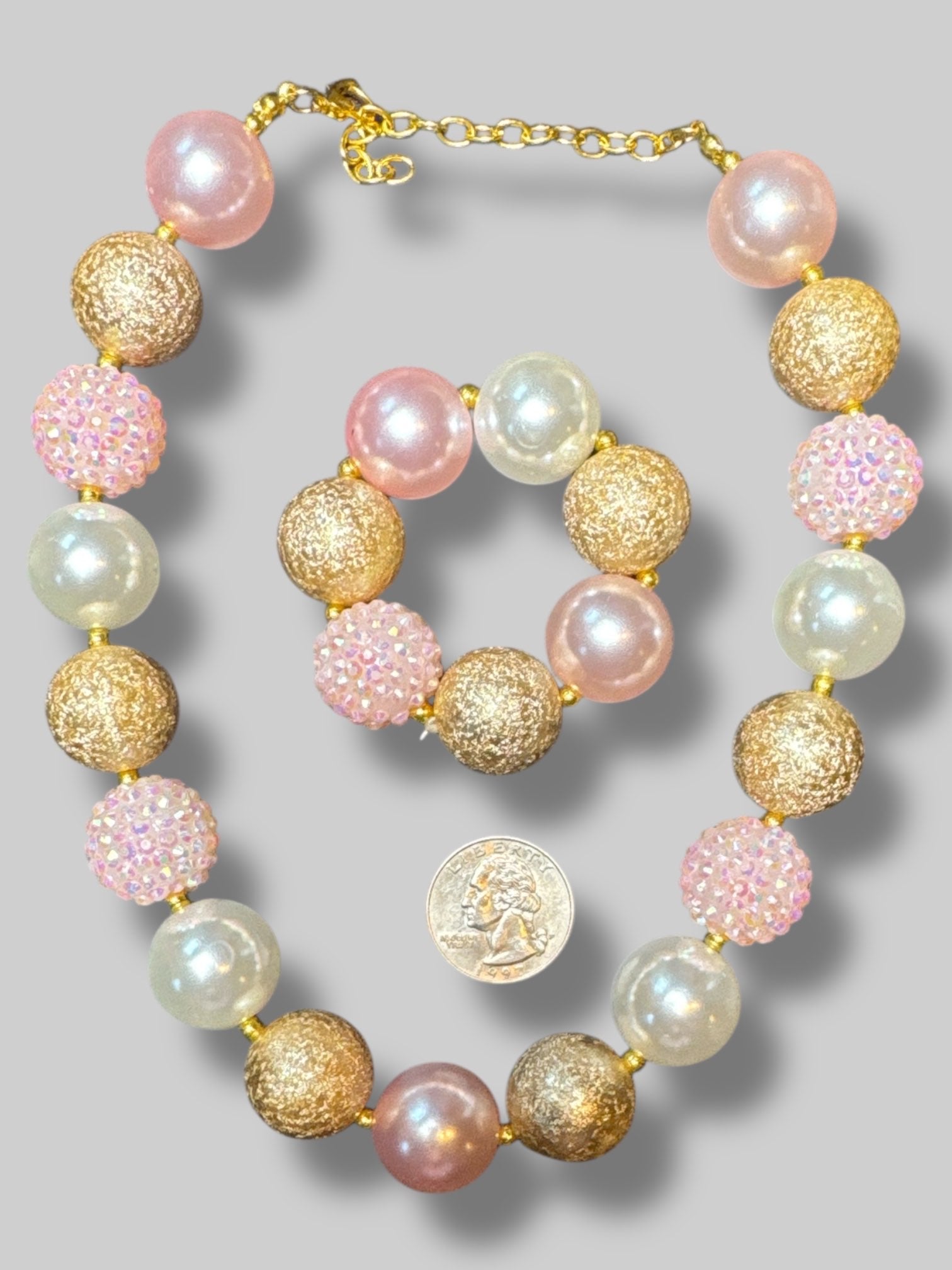 Matching necklace and bracelet with big chunky pink, white, and gold beads