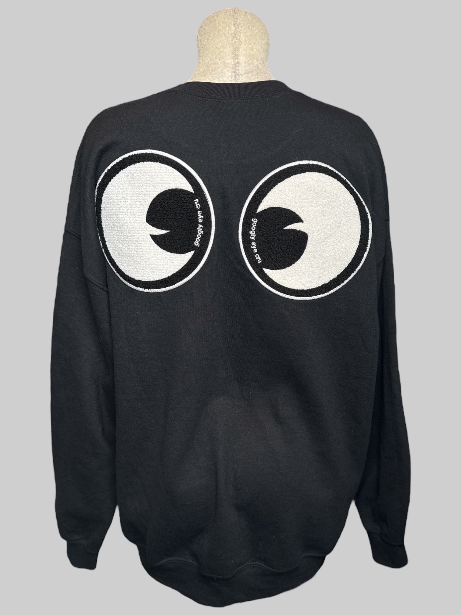 2X black pullover sweater with embroidered googly eyes on front and back