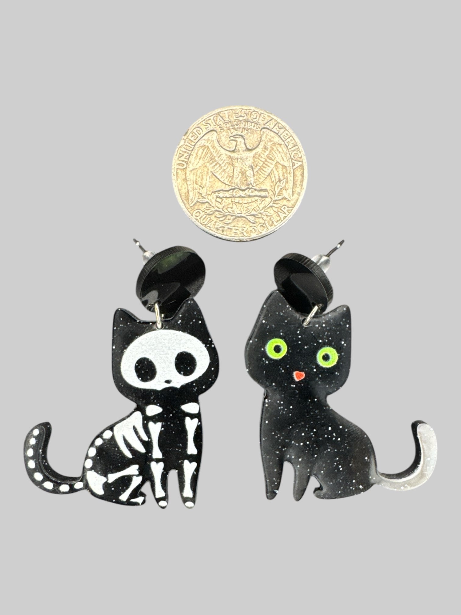 Pair of black cat earrings, one skeleton, one with green eyes