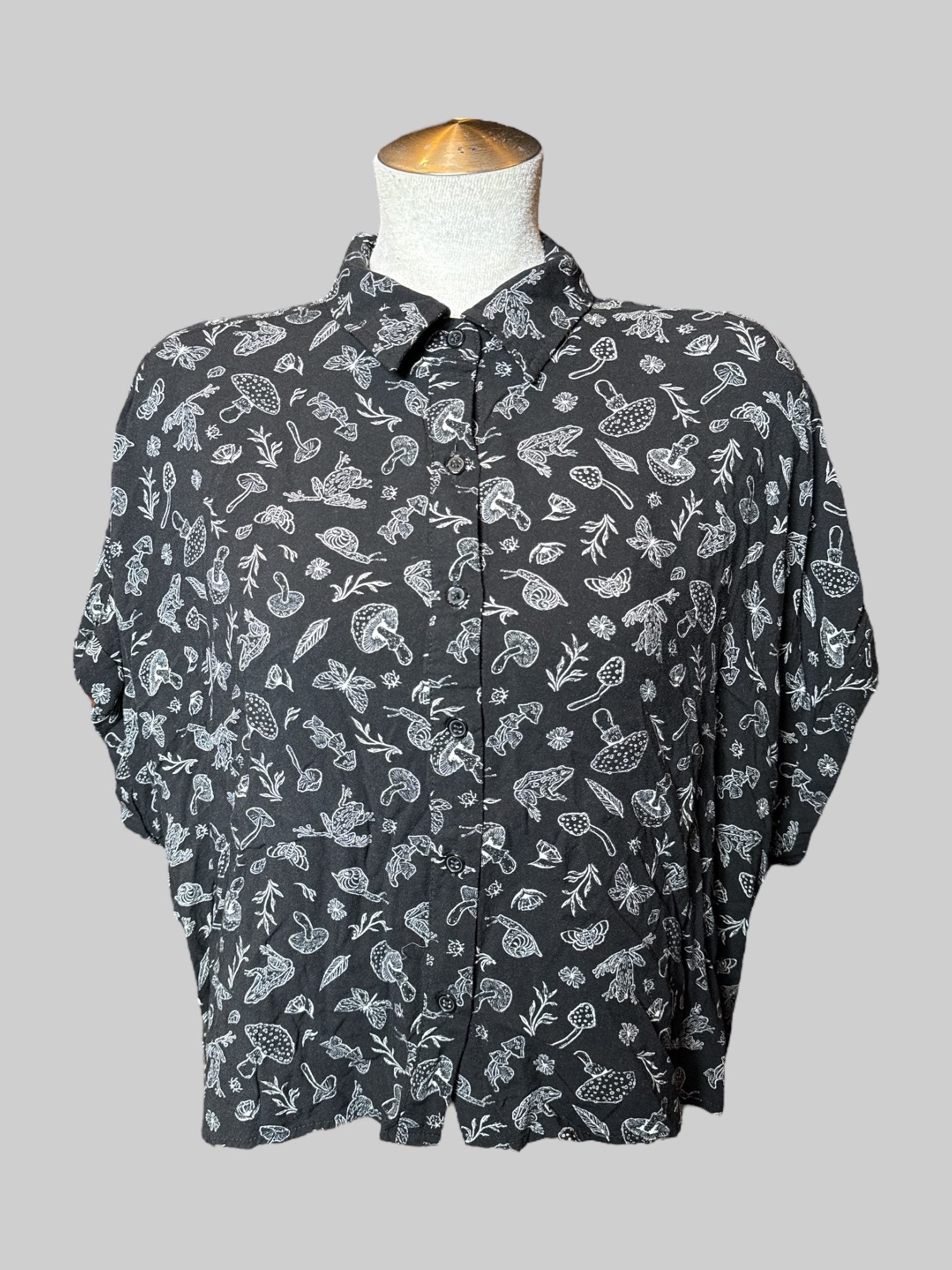 L black crocs, short sleeve button down with mushrooms, frogs, and plant print