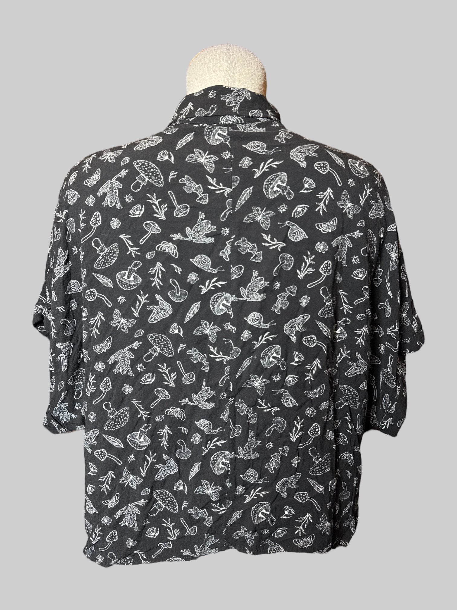 L black crocs, short sleeve button down with mushrooms, frogs, and plant print