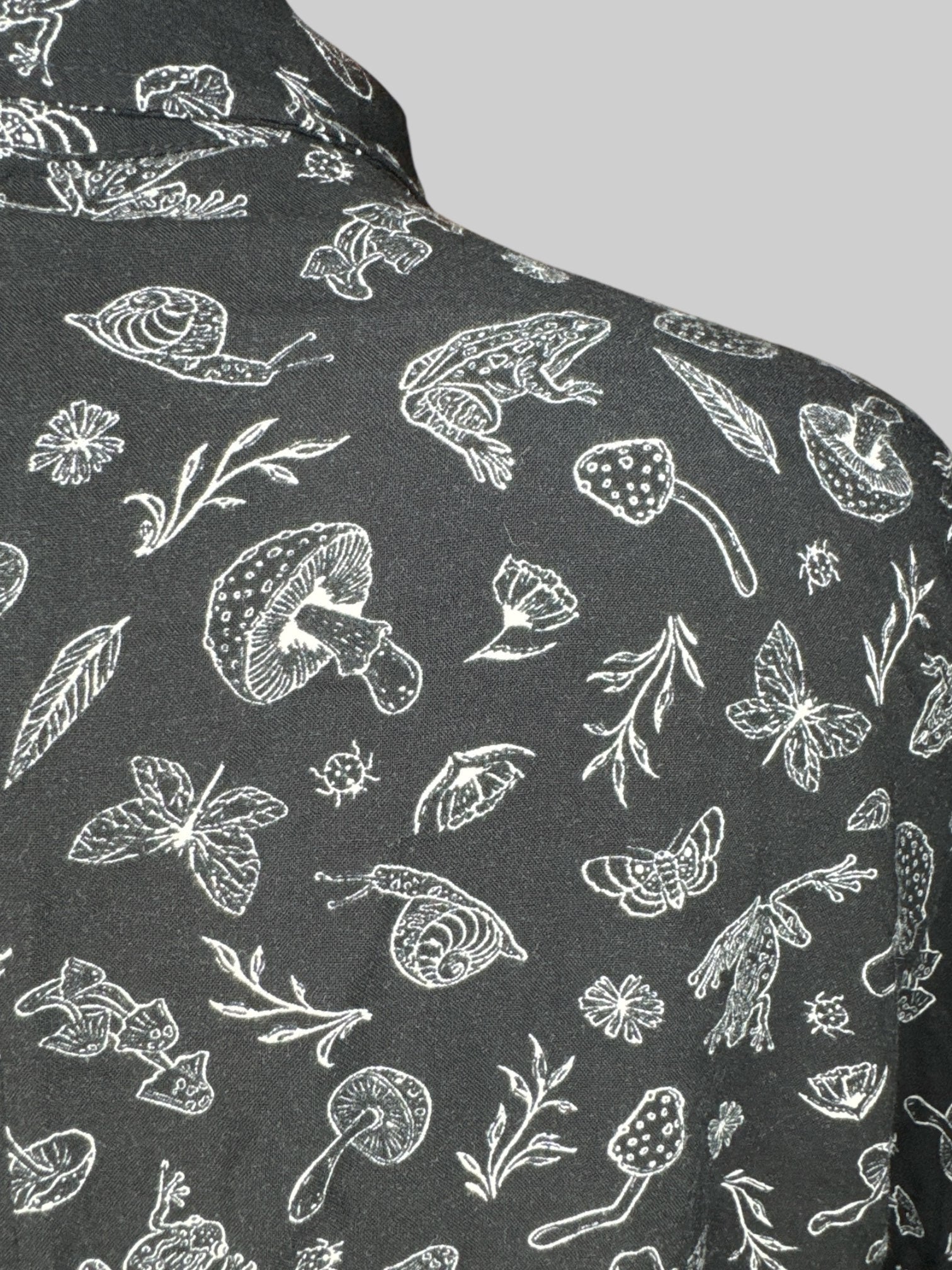 L black crocs, short sleeve button down with mushrooms, frogs, and plant print