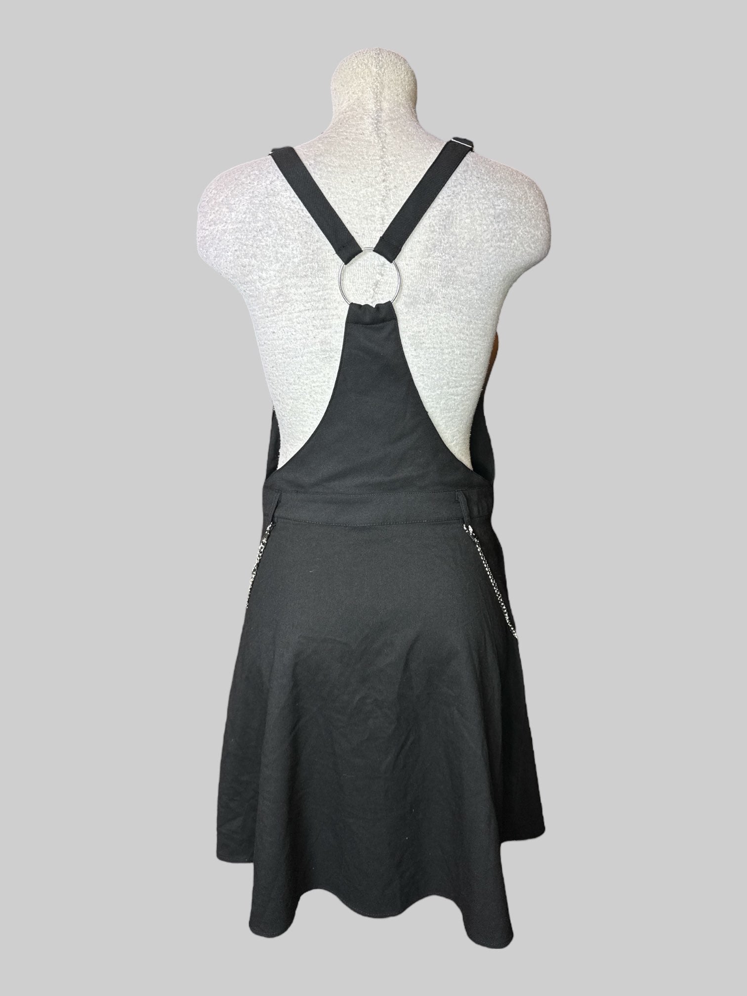 L black sleeveless dress with overall style straps, half zipper on front, belt, loops, and chain
