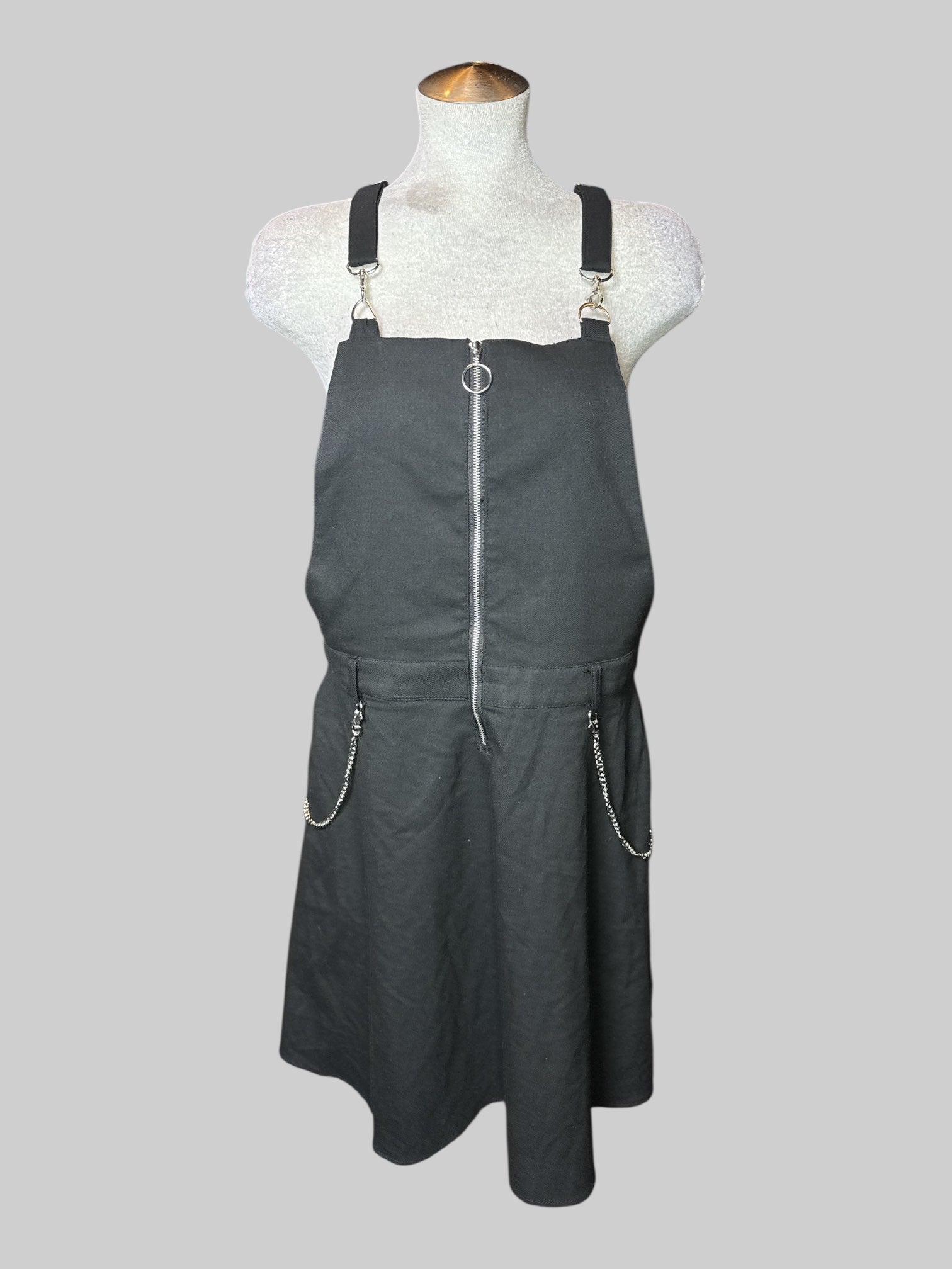L black sleeveless dress with overall style straps, half zipper on front, belt, loops, and chain