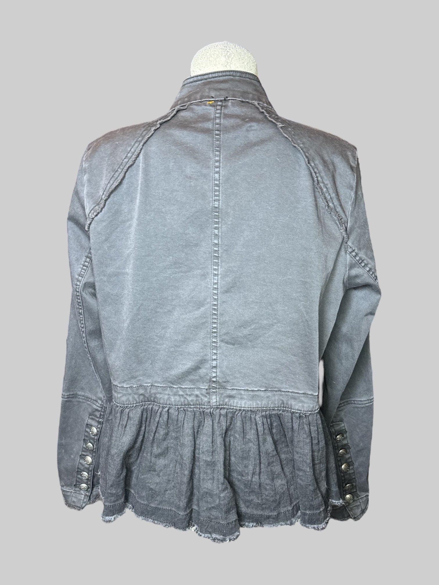 L black open jacket with decorative buttons on front and cuffs, panels on bottom, and fringe detail details