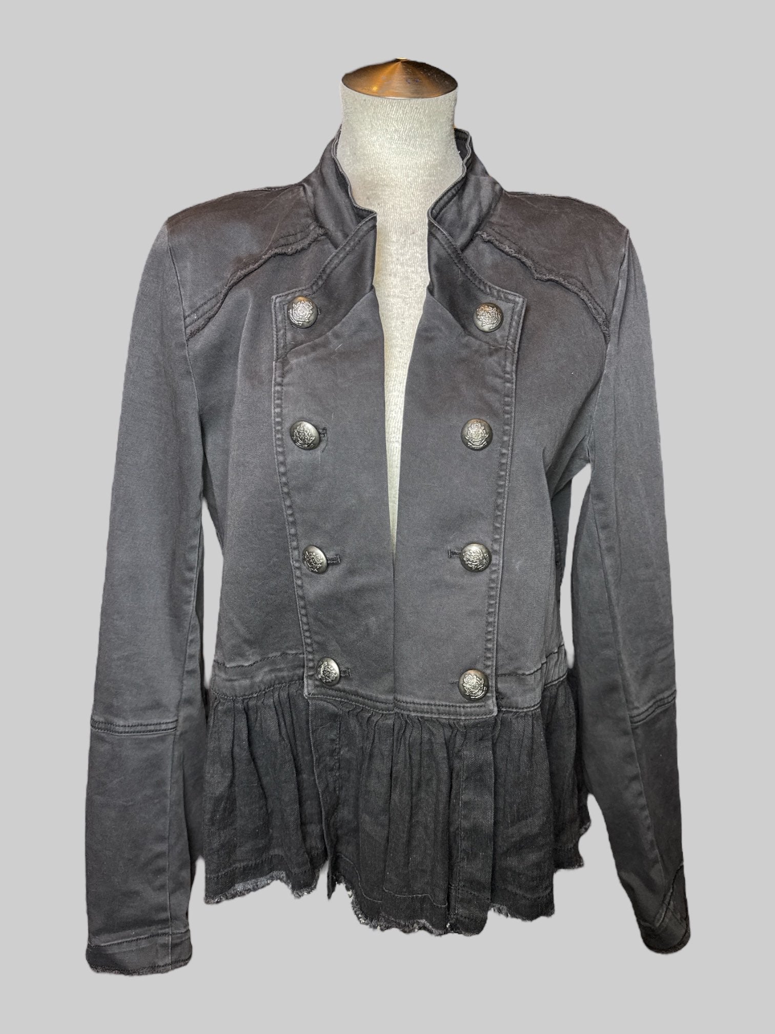 L black open jacket with decorative buttons on front and cuffs, panels on bottom, and fringe detail details