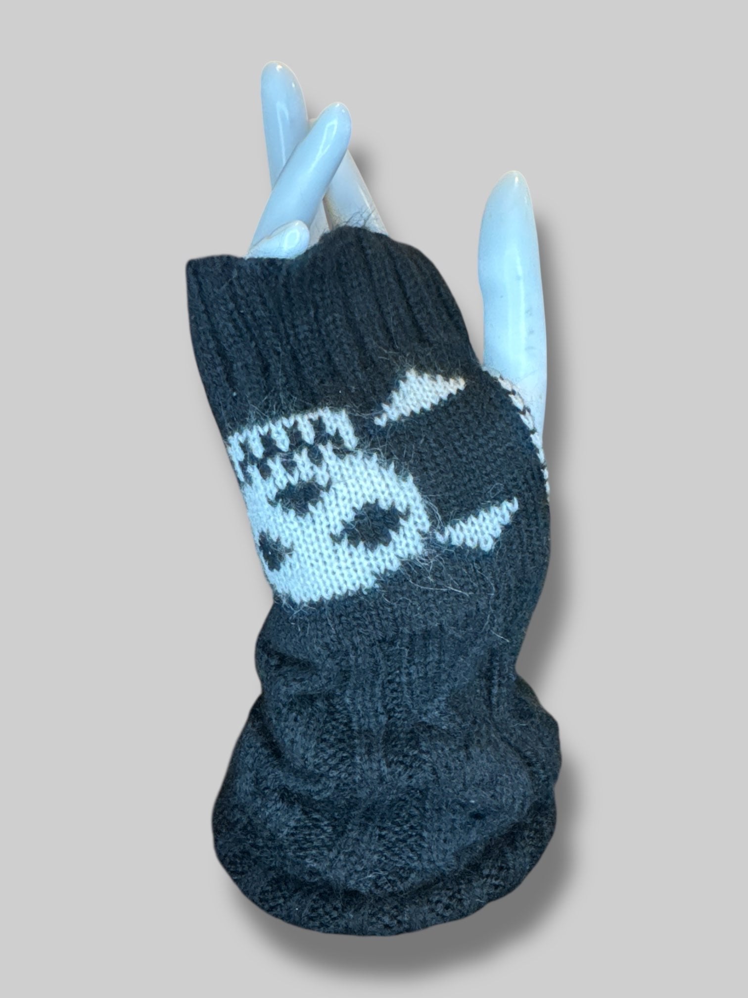 Black knit wrist warmers with thumb hole, and skull design