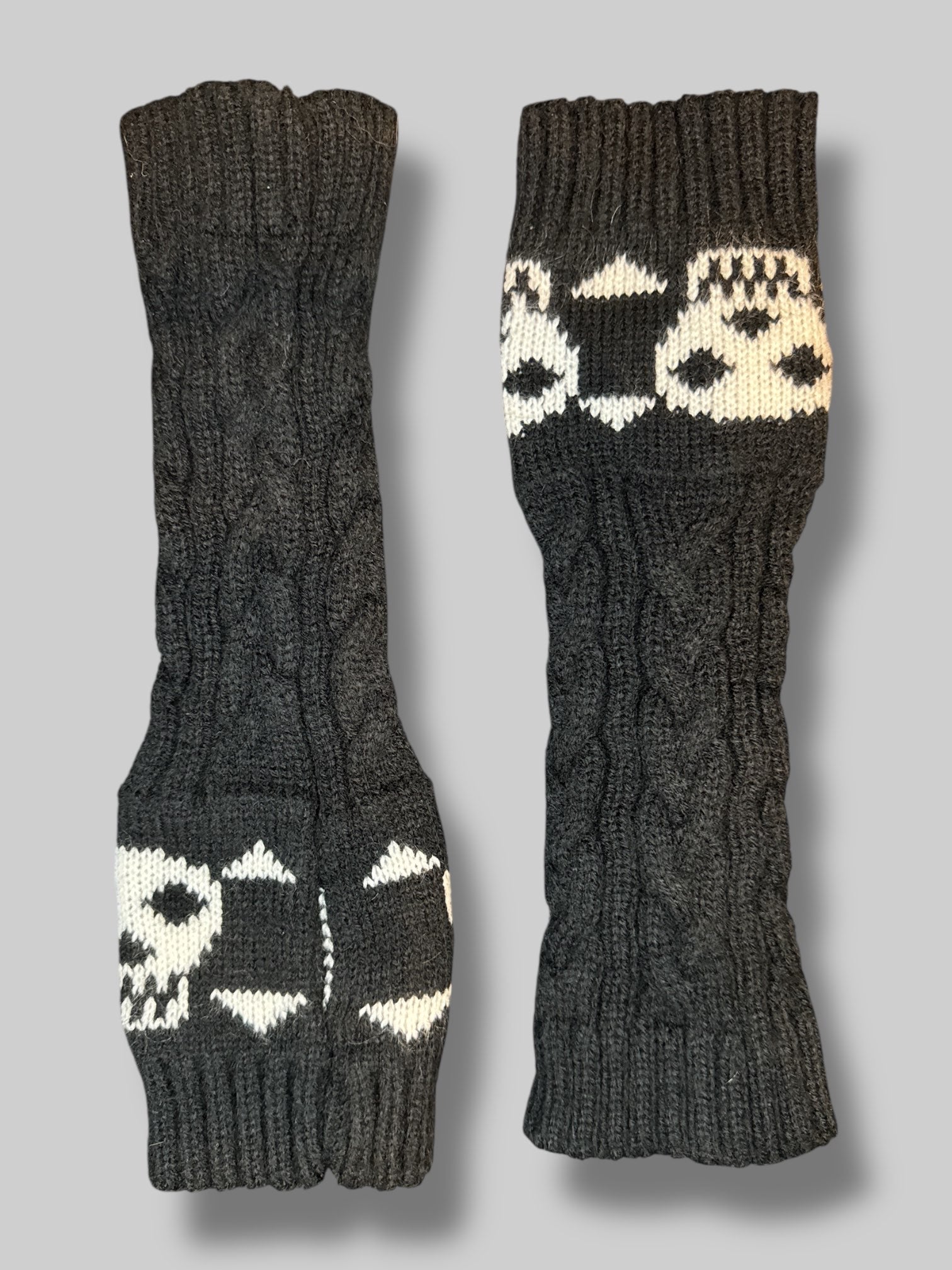 Black knit wrist warmers with thumb hole, and skull design