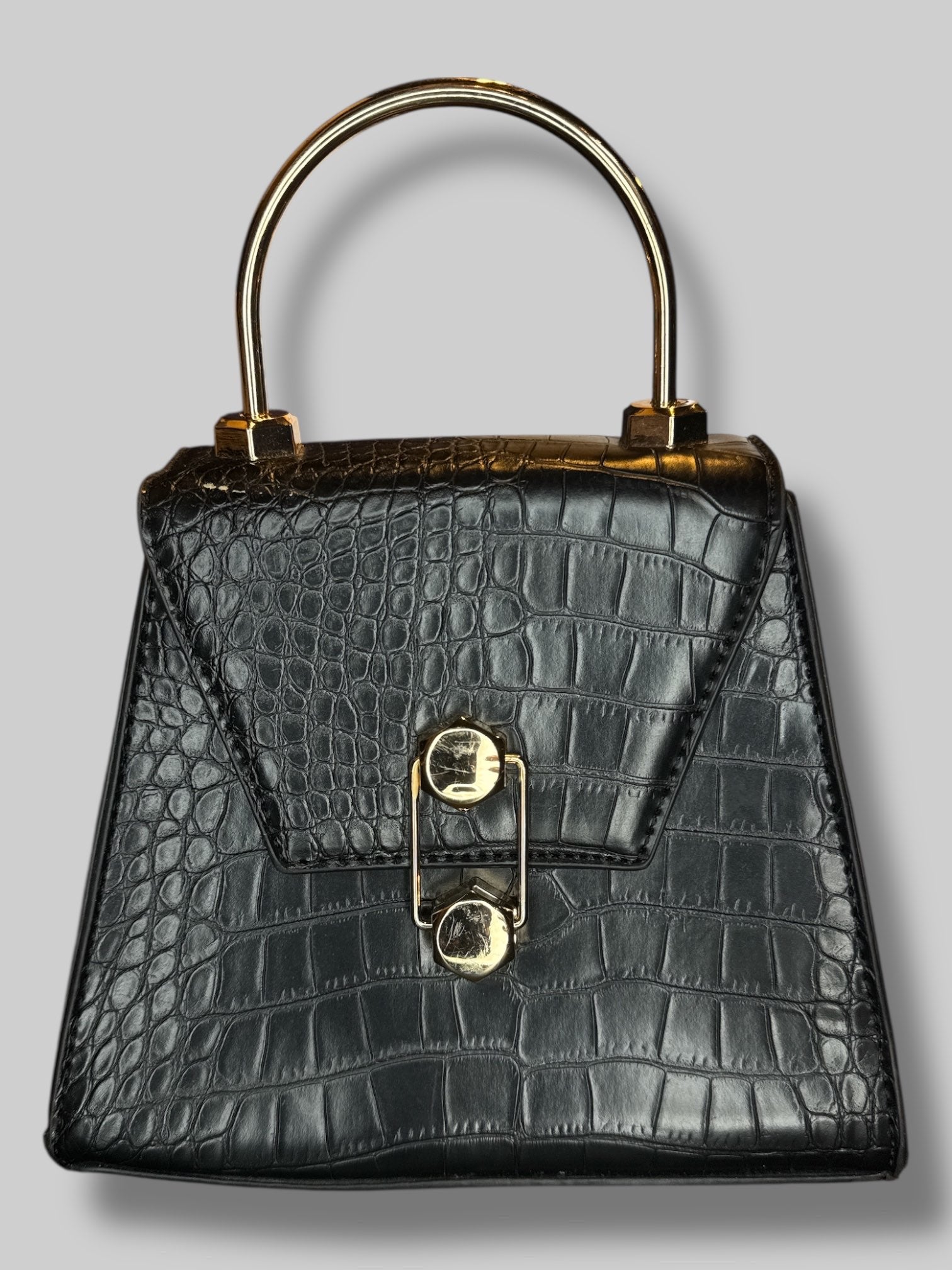 Black, small leather handbag with unique clasp, and D rings for a shoulder strap