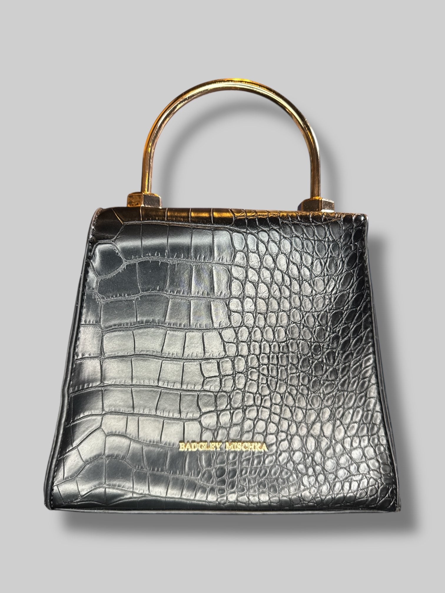 Black, small leather handbag with unique clasp, and D rings for a shoulder strap