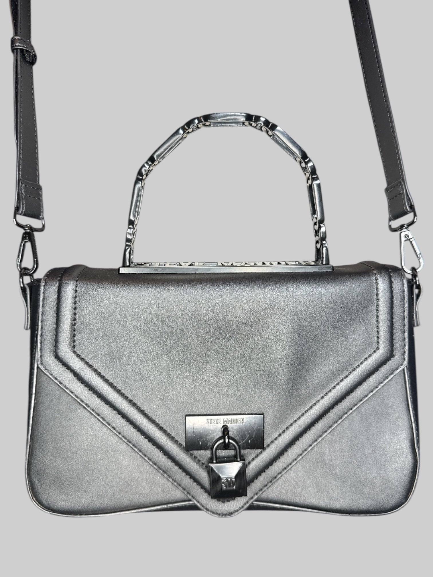 Black leather Steve Madden handbag with hard handle, shoulder strap, faux lock on front, and snap closure