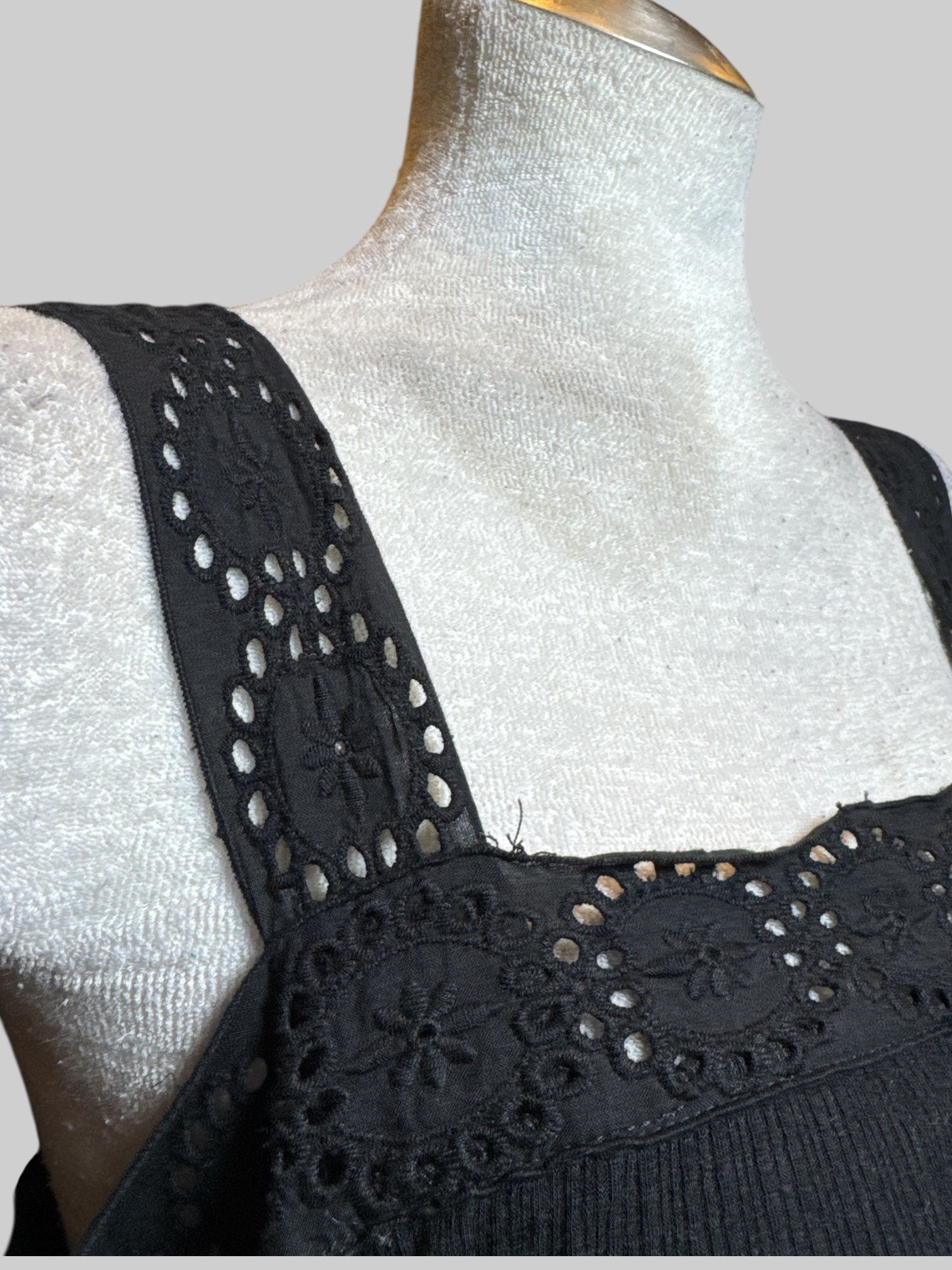 2X black sleeveless top with lattice cutouts and lettuce trim