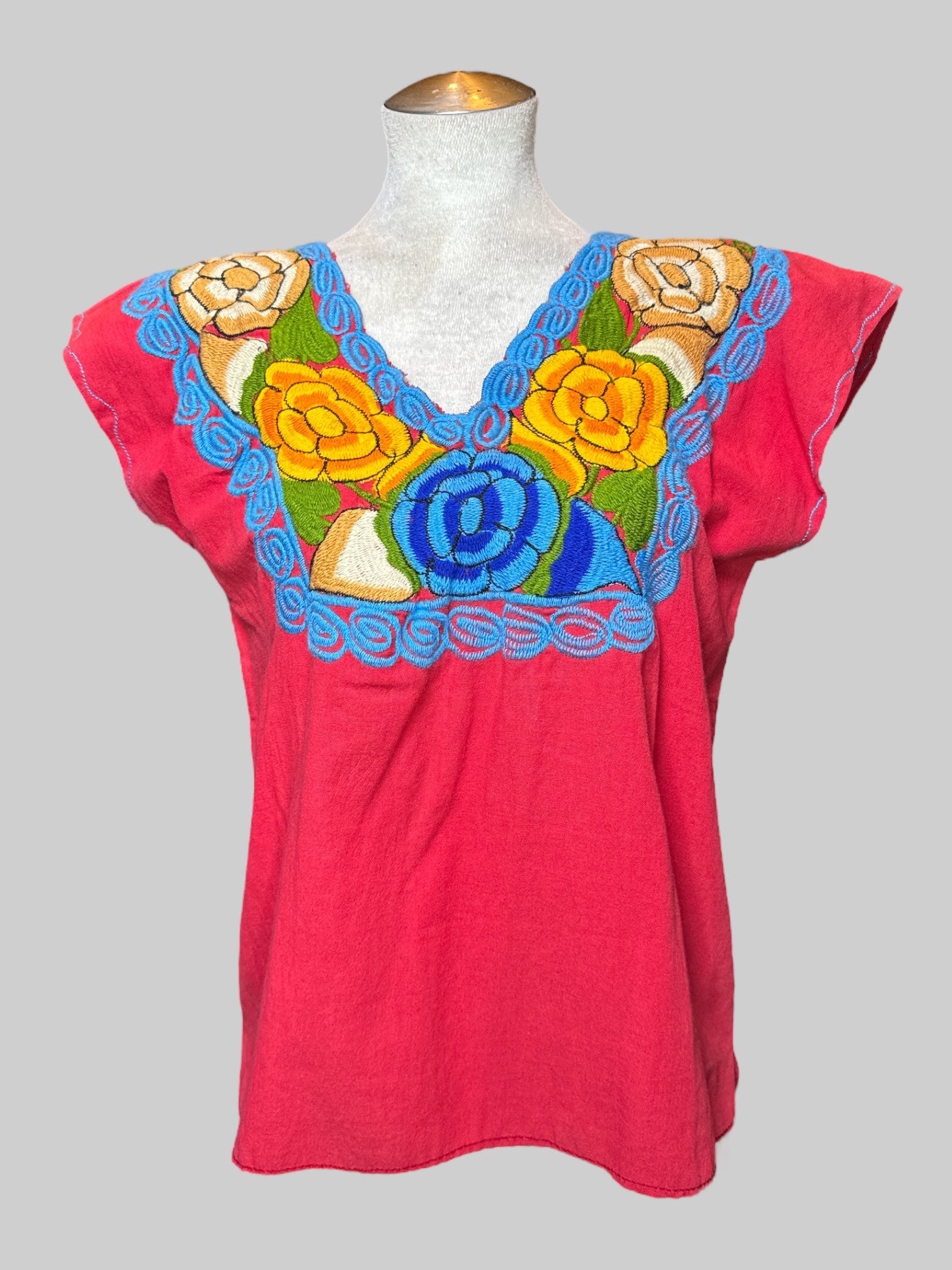 L red shorts, top with blue, yellow and brown floral embroidery on McCline, and flared sleeves