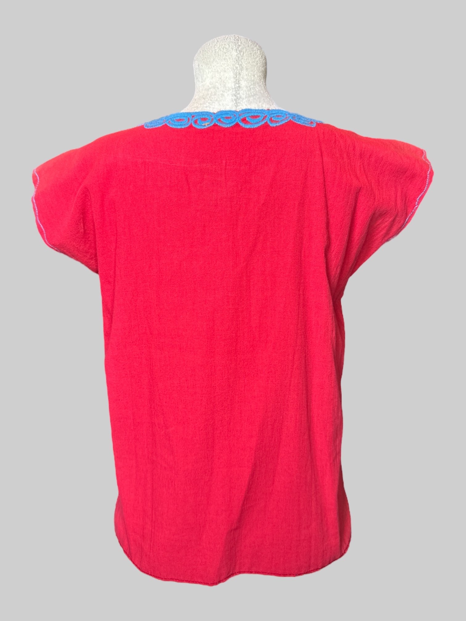 L red shorts, top with blue, yellow and brown floral embroidery on McCline, and flared sleeves