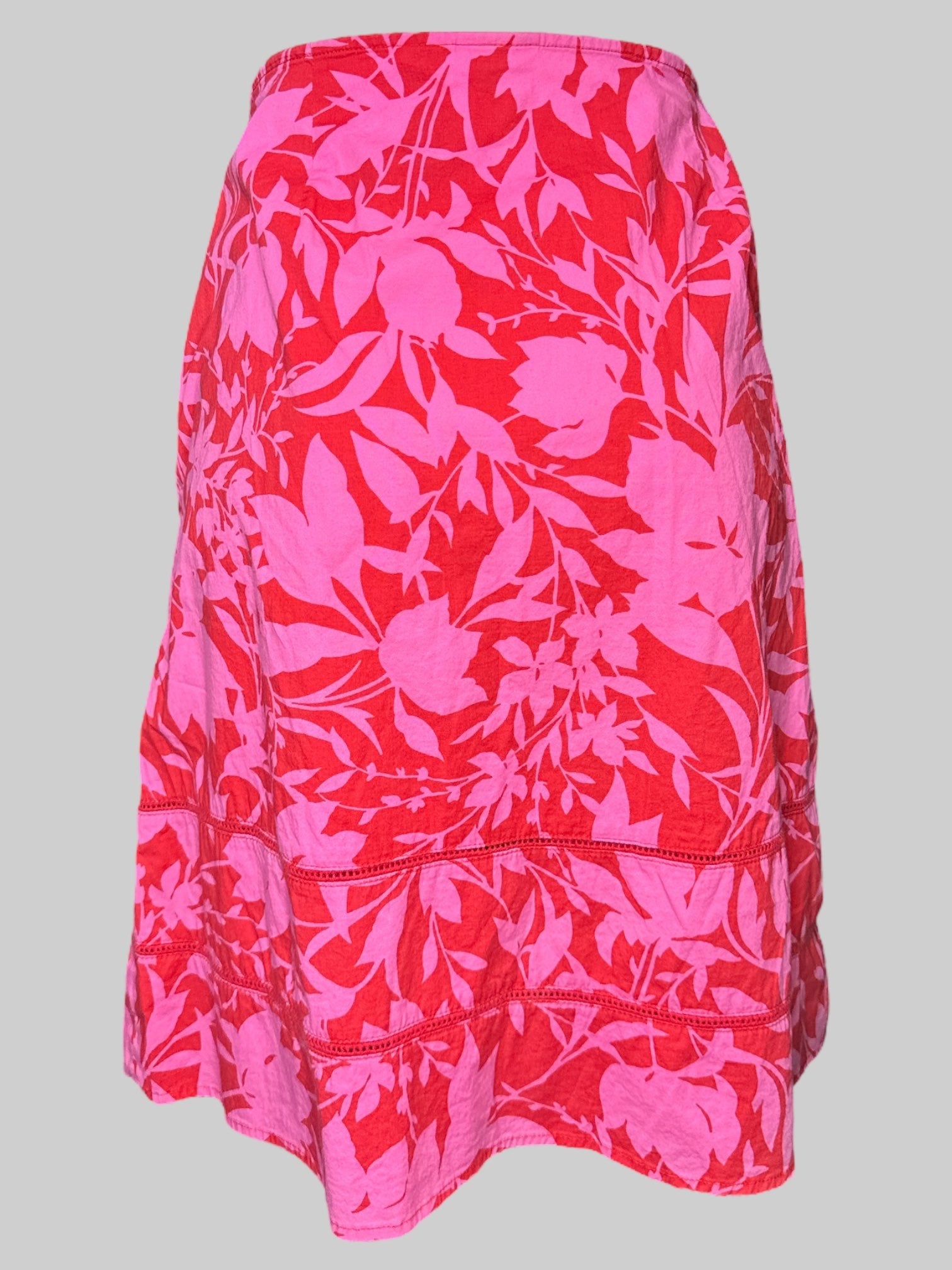 L red and pink floral skirt with crochet mesh lines on bottom, and zipper on side