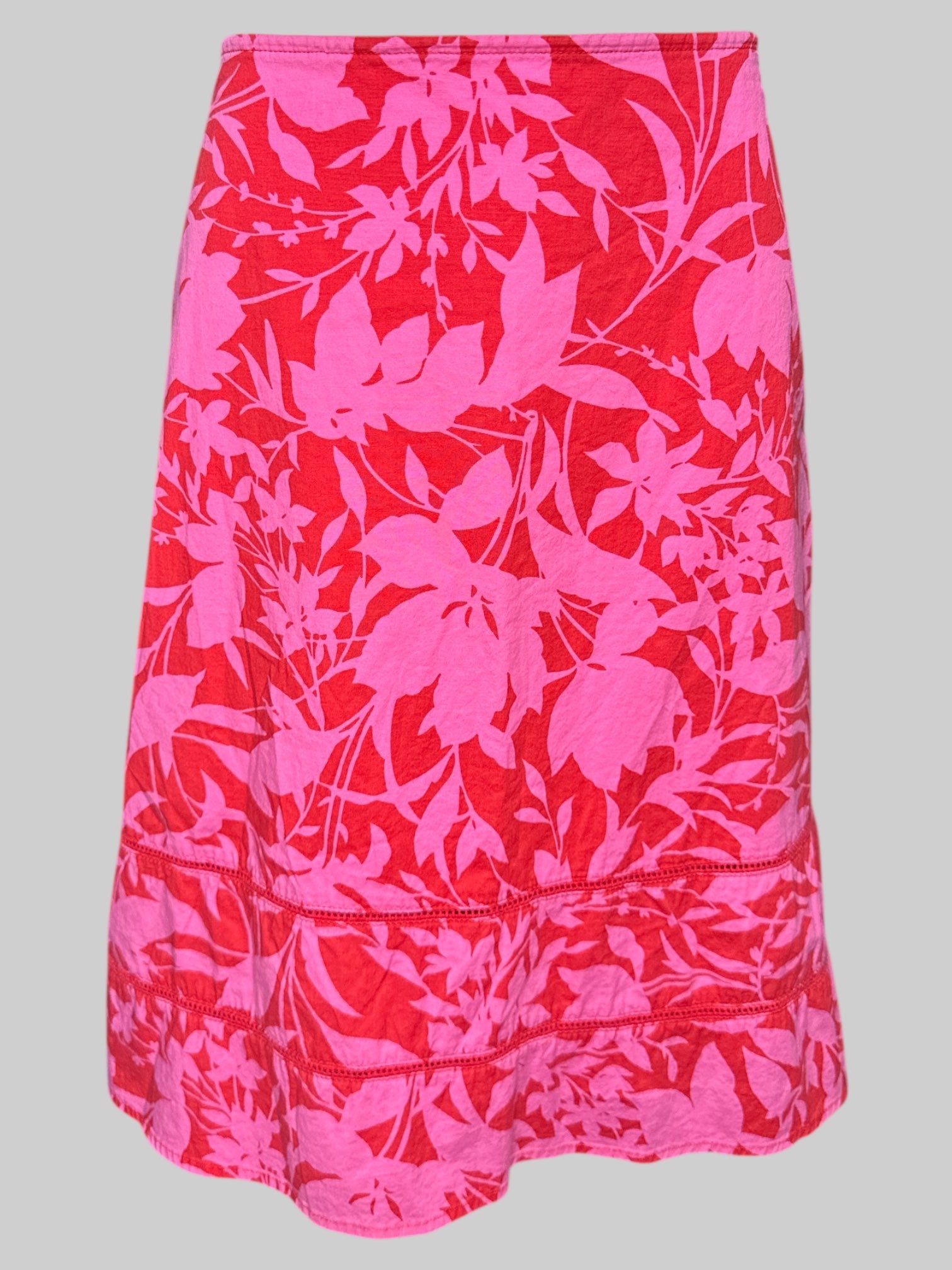 L red and pink floral skirt with crochet mesh lines on bottom, and zipper on side