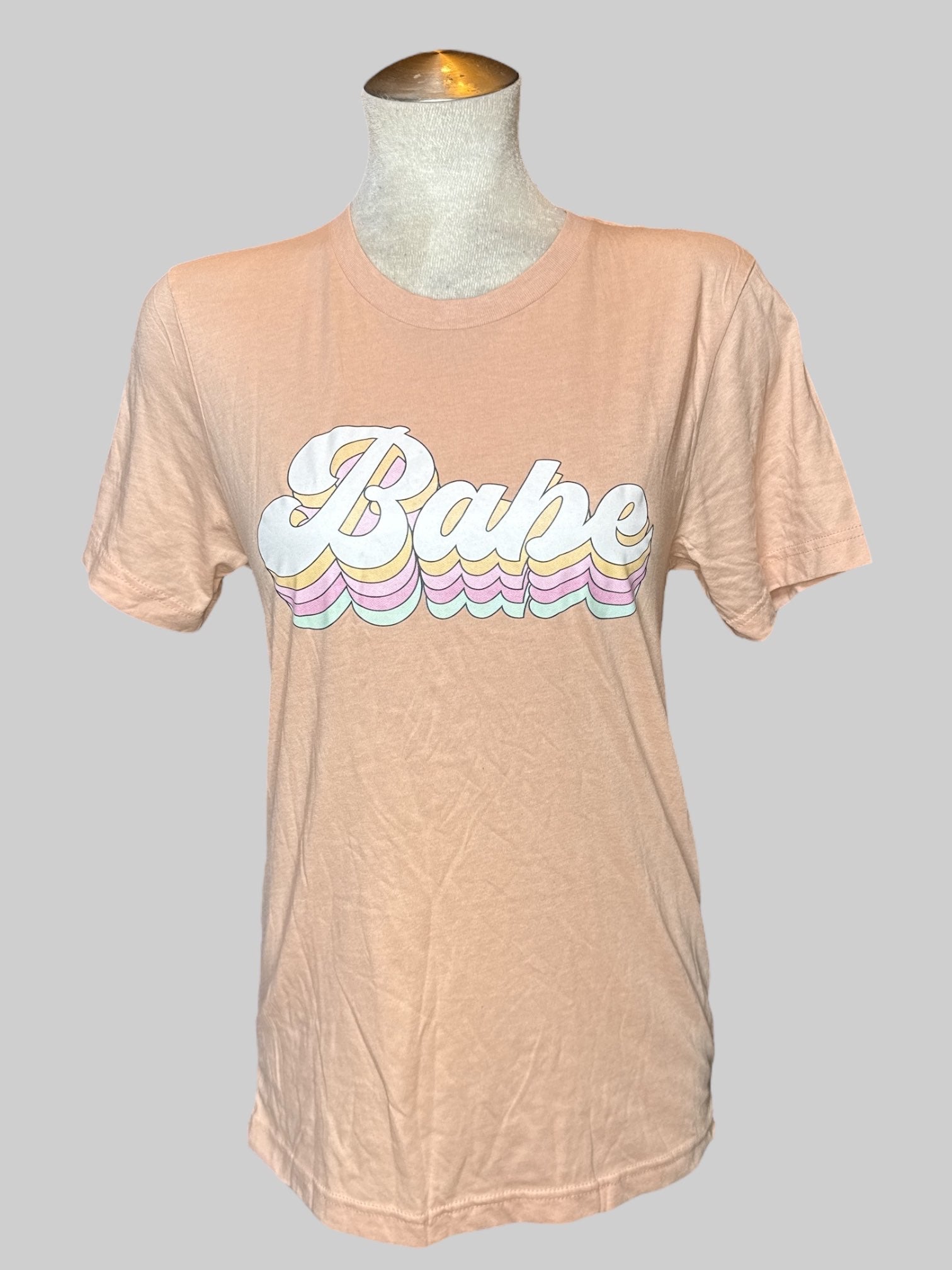 0X light orange tee with “babe“ graphic on front