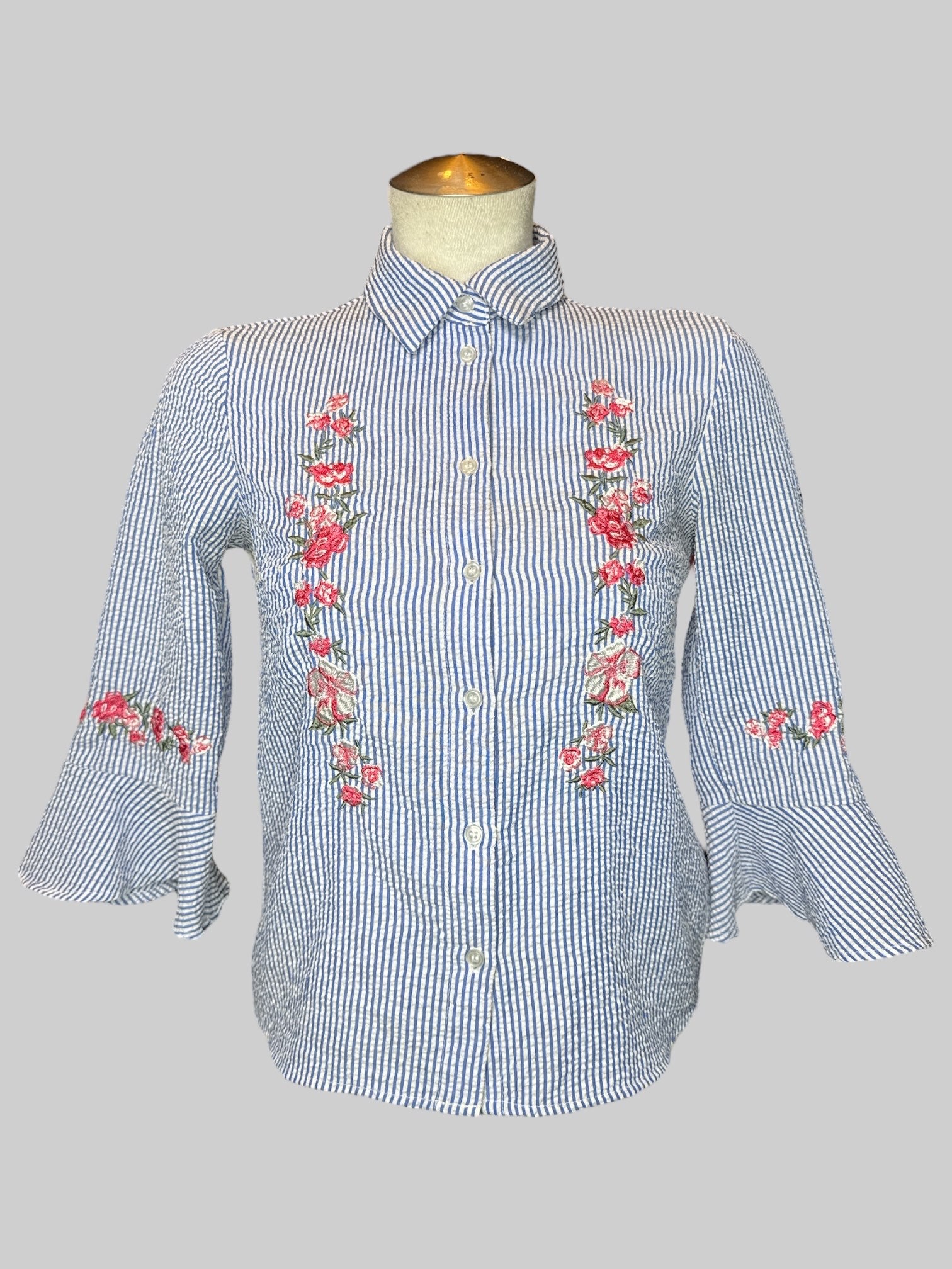 S blue and white straight button-down with flared sleeves, and pink floral embroidery on front and cuffs