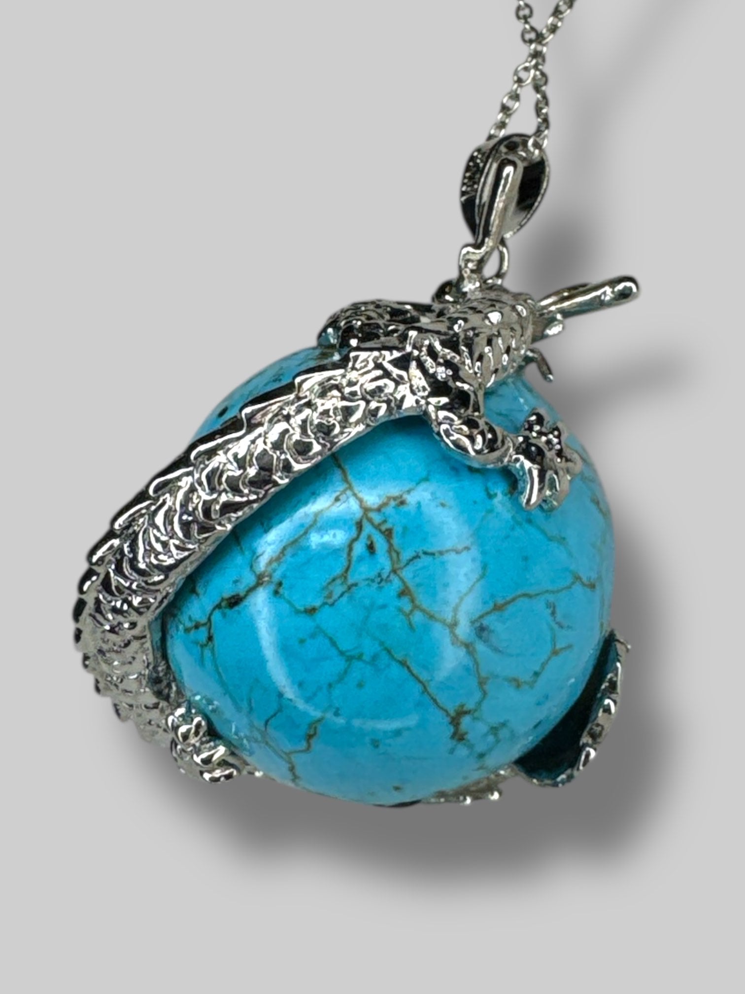 Circular  turquoise stone with silver tone dragon