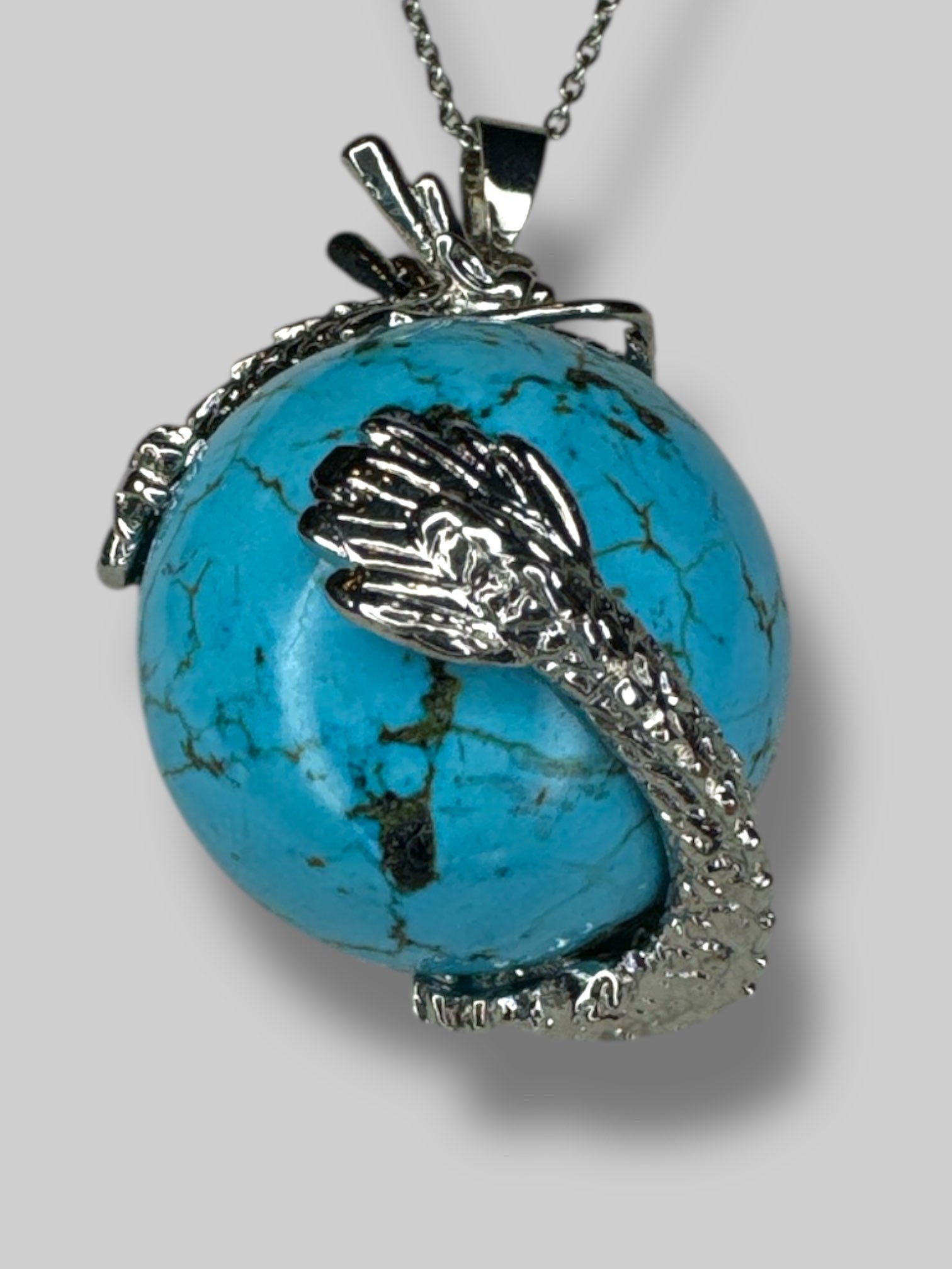 Circular  turquoise stone with silver tone dragon
