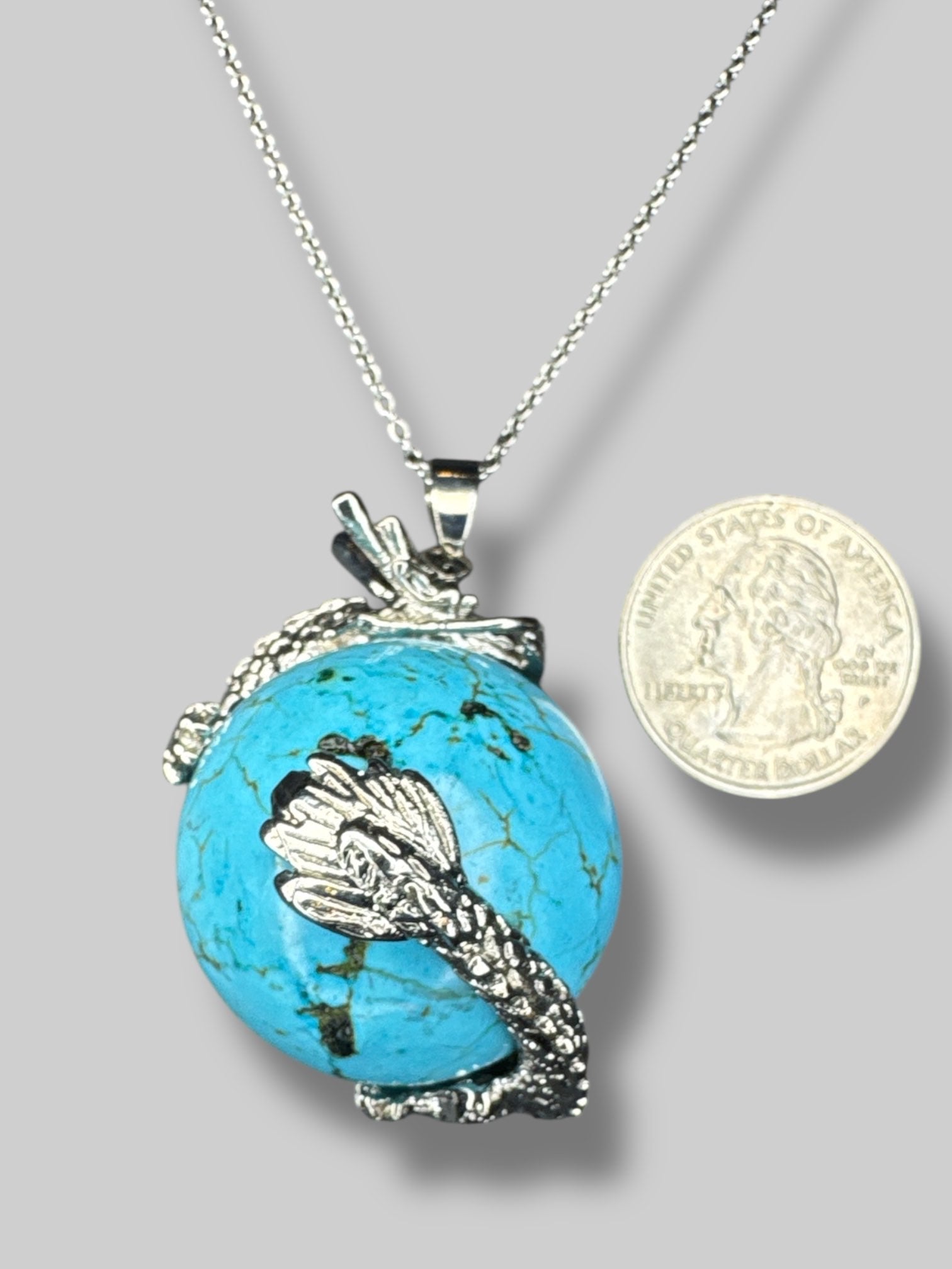 Circular  turquoise stone with silver tone dragon