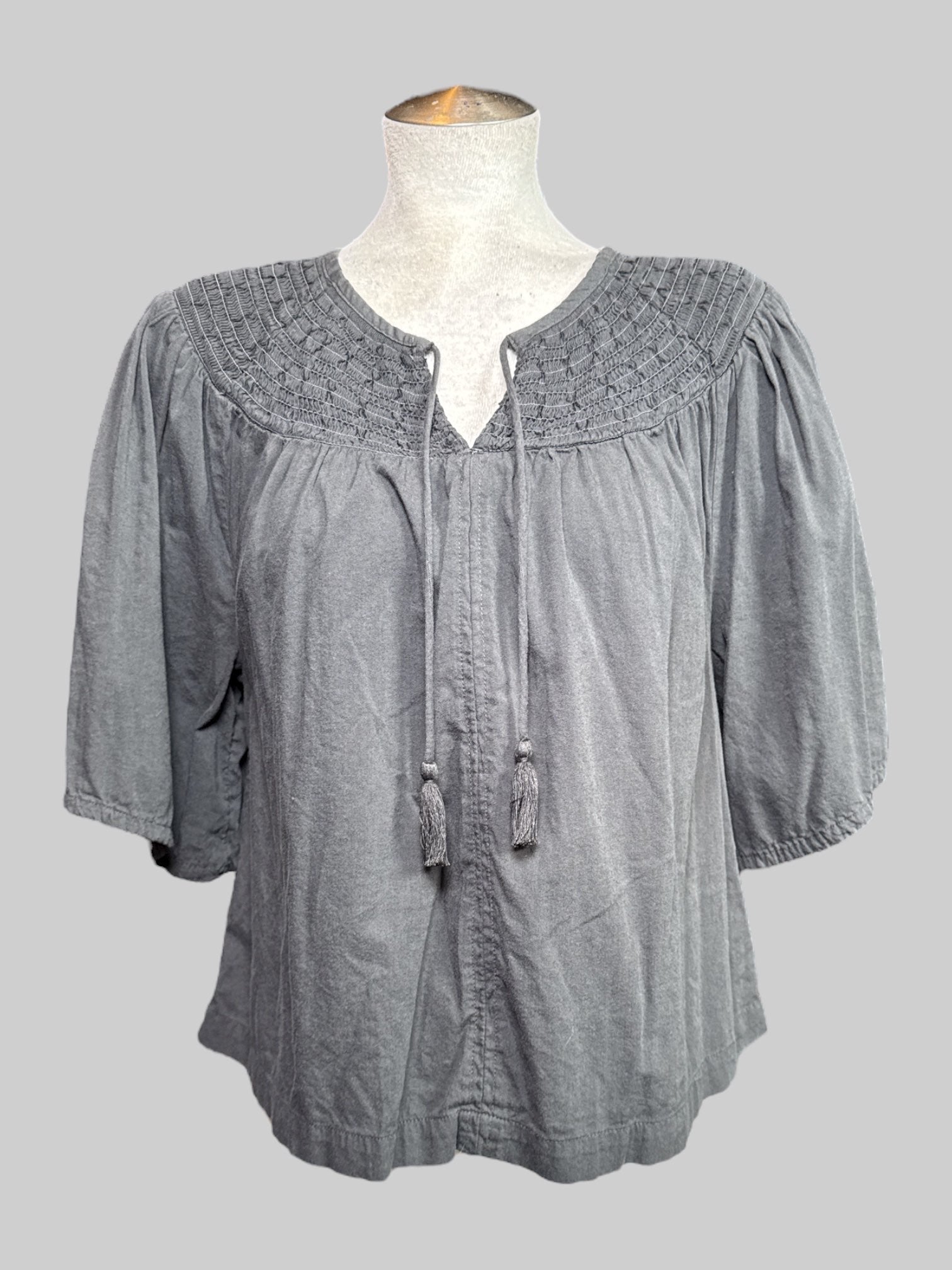 L gray short sleeve floaty top with shirred collar and tie with tassels on neck line
