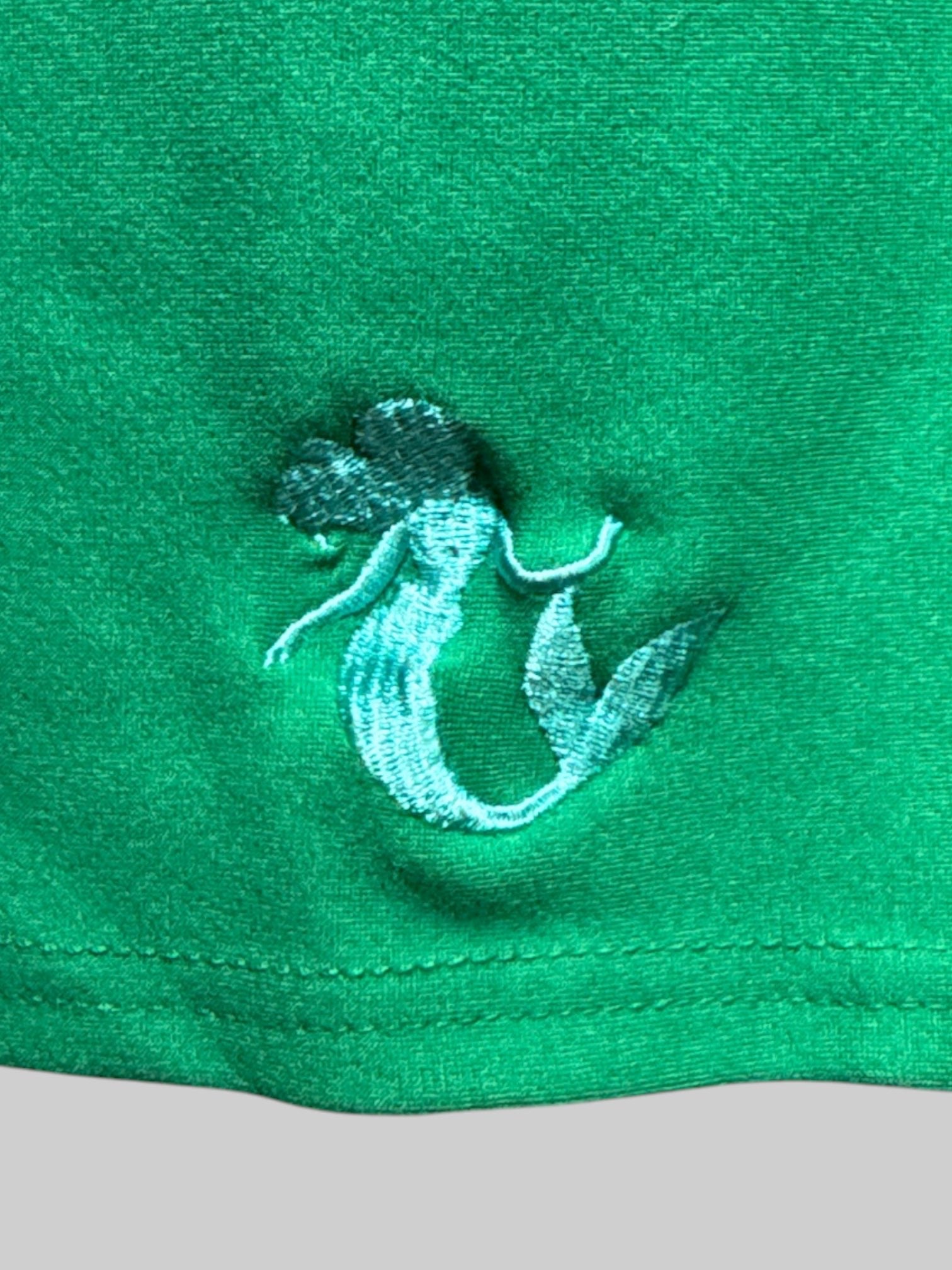 2X two piece, set Disney’s The Little Mermaid themed skirt and top with little mermaid emblems on bottom of skirt and sleeve of top, and tie on top