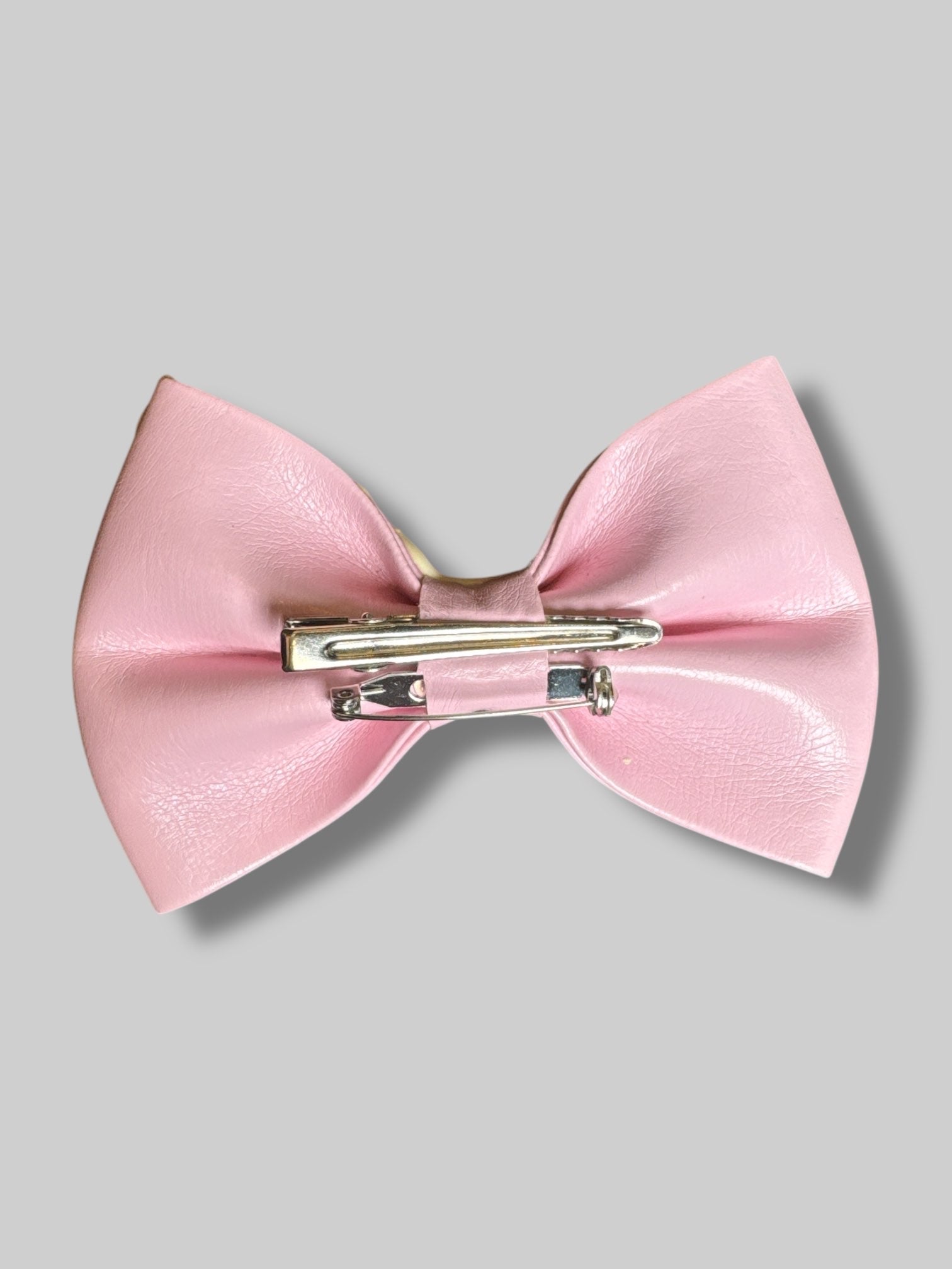 4” Pink leather bow with pin and clasp on back, and icing with sprinkle design
