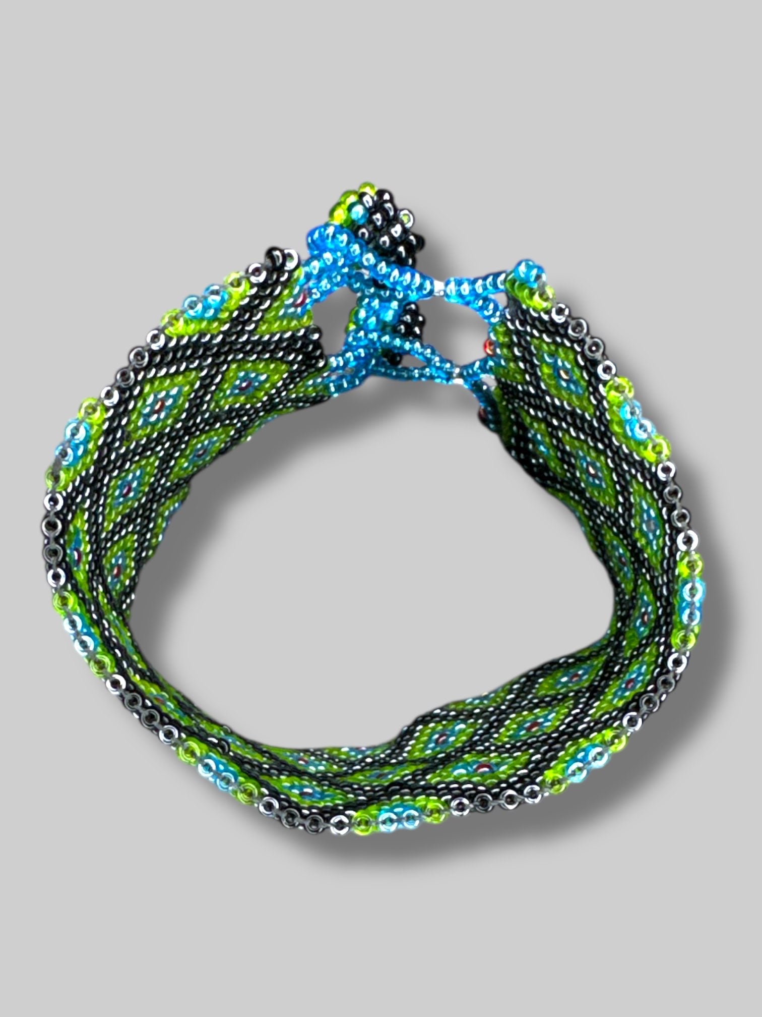 7” long unclasped beautiful green, blue, black, and red beaded bracelet