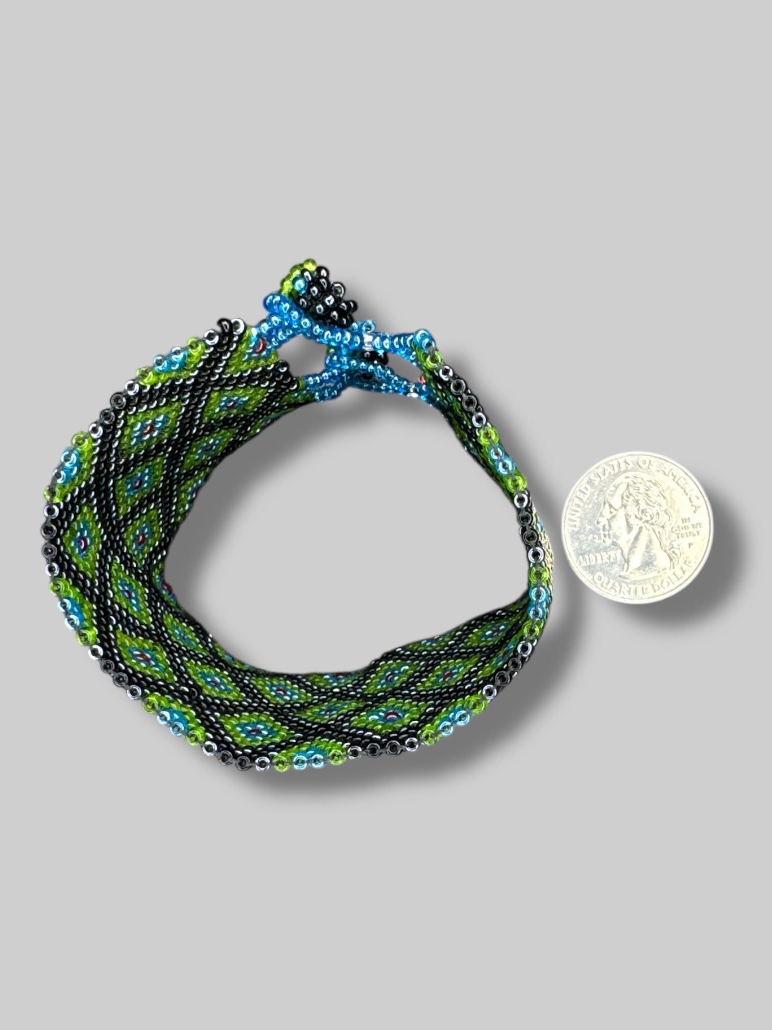 7” long unclasped beautiful green, blue, black, and red beaded bracelet