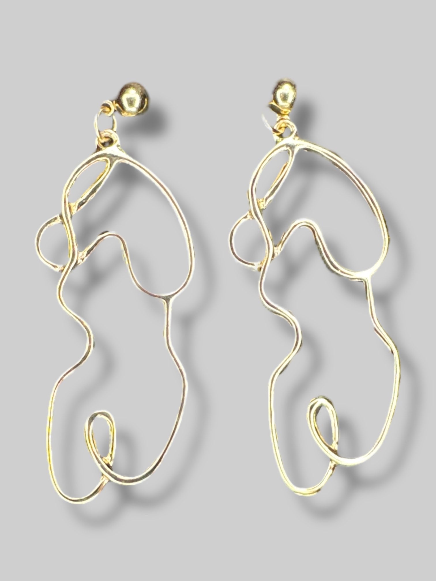 Goldtone abstract outline of body earrings