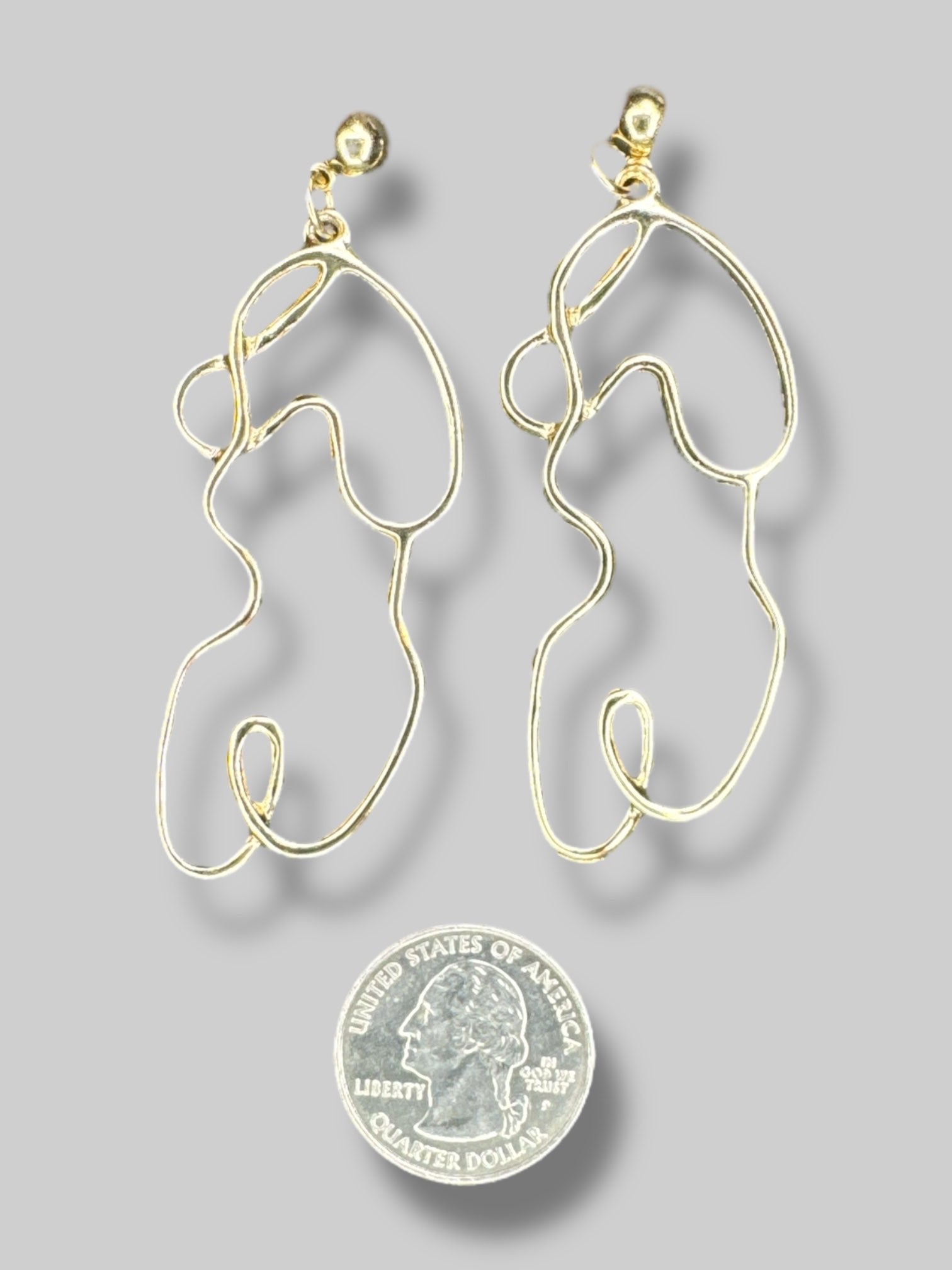 Goldtone abstract outline of body earrings